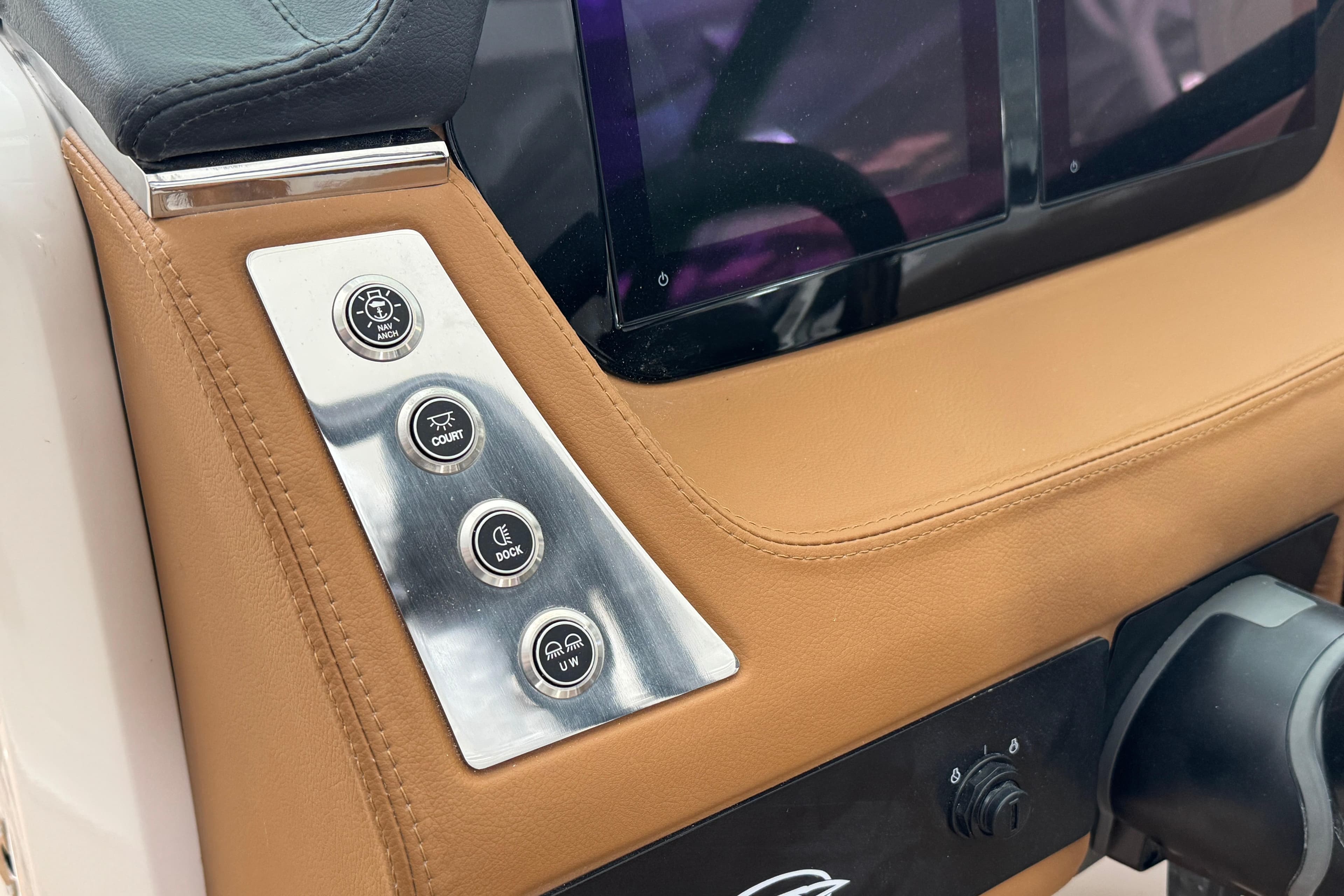 Control panel of 2026 Chaparral 250 OSX boat with leather trim and buttons.