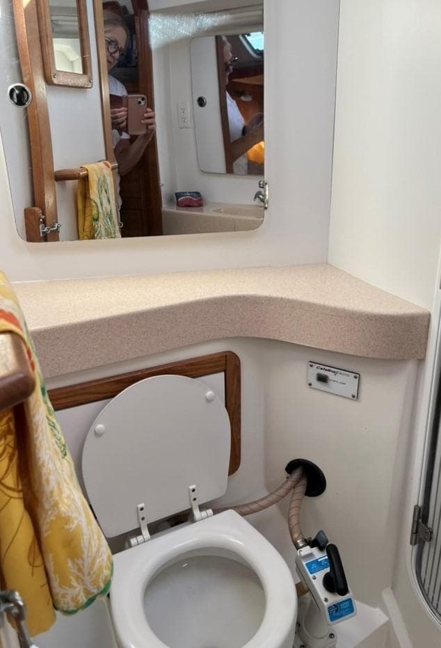 Bathroom interior of a 1998 Catalina 42 Mk II yacht, featuring a toilet and mirror.