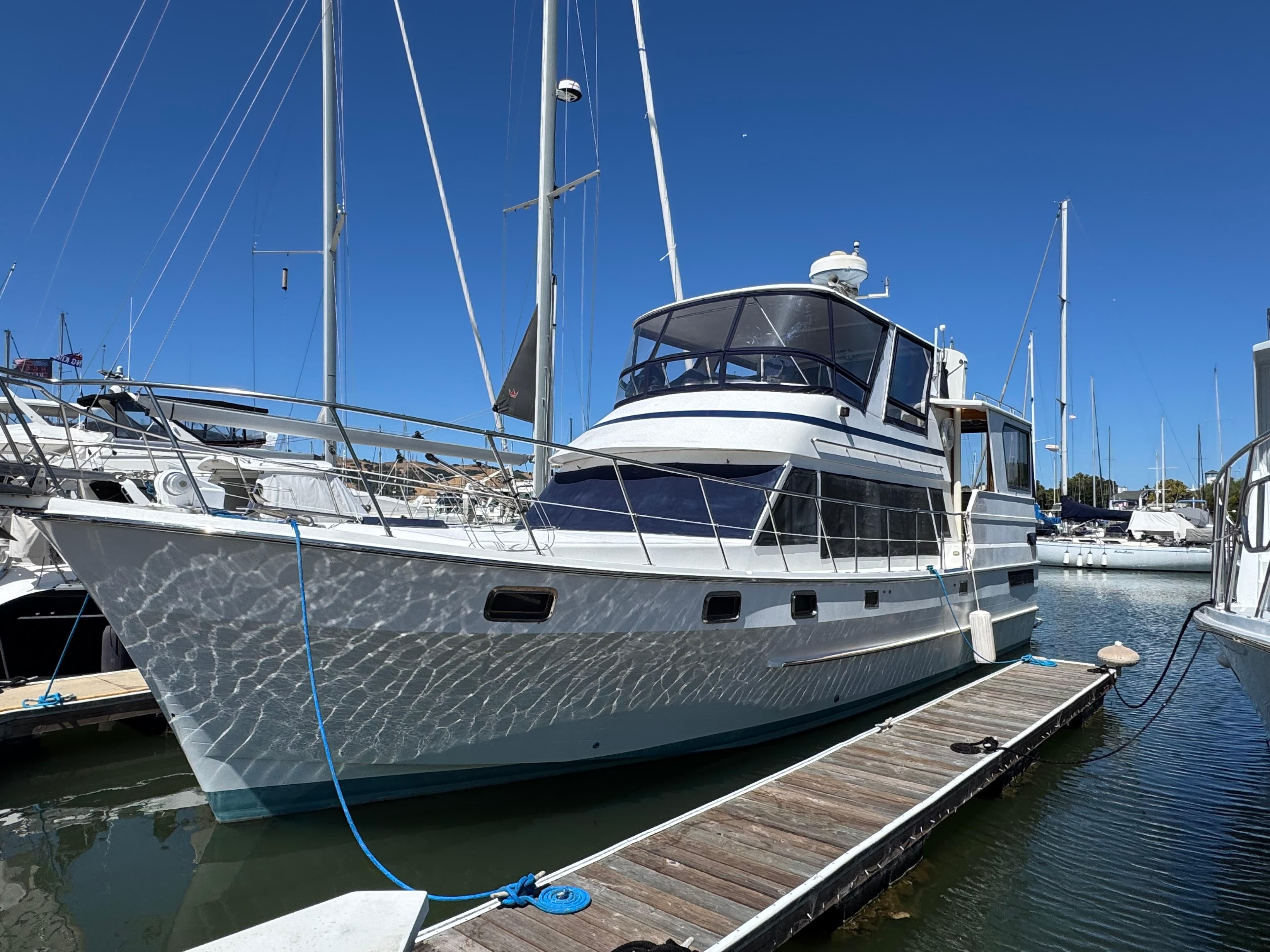 White Nova 48 yacht from 1990 docked at marina under clear blue sky.