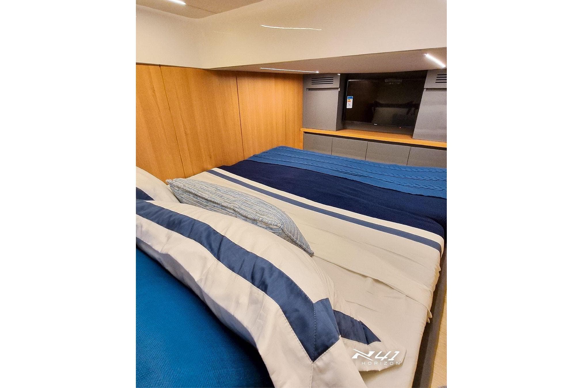 Luxurious bedroom interior of 2025 NX Boats NX41 HORIZON with striped bedding.