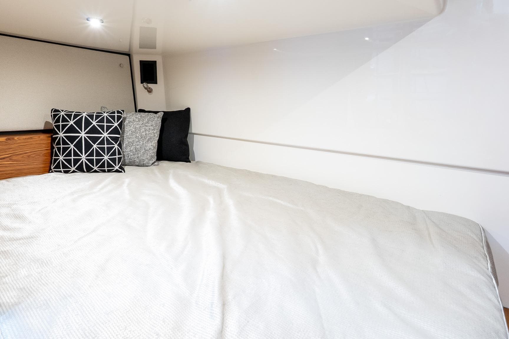 2024 Boston Whaler 405 Conquest cabin interior with cozy bed and decorative pillows.