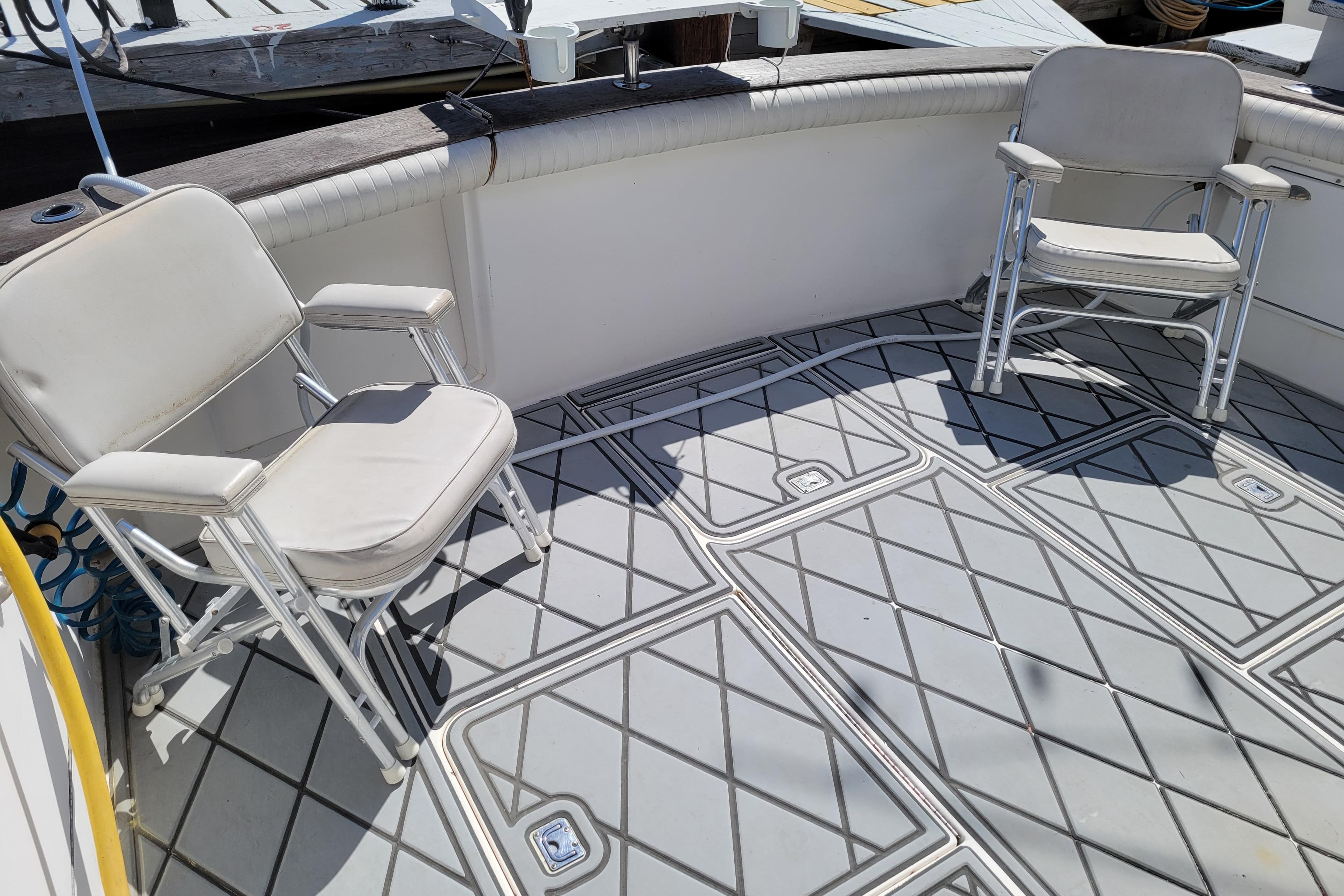 1993 Ocean Yachts 38 Super Sport deck with two white chairs and patterned flooring.