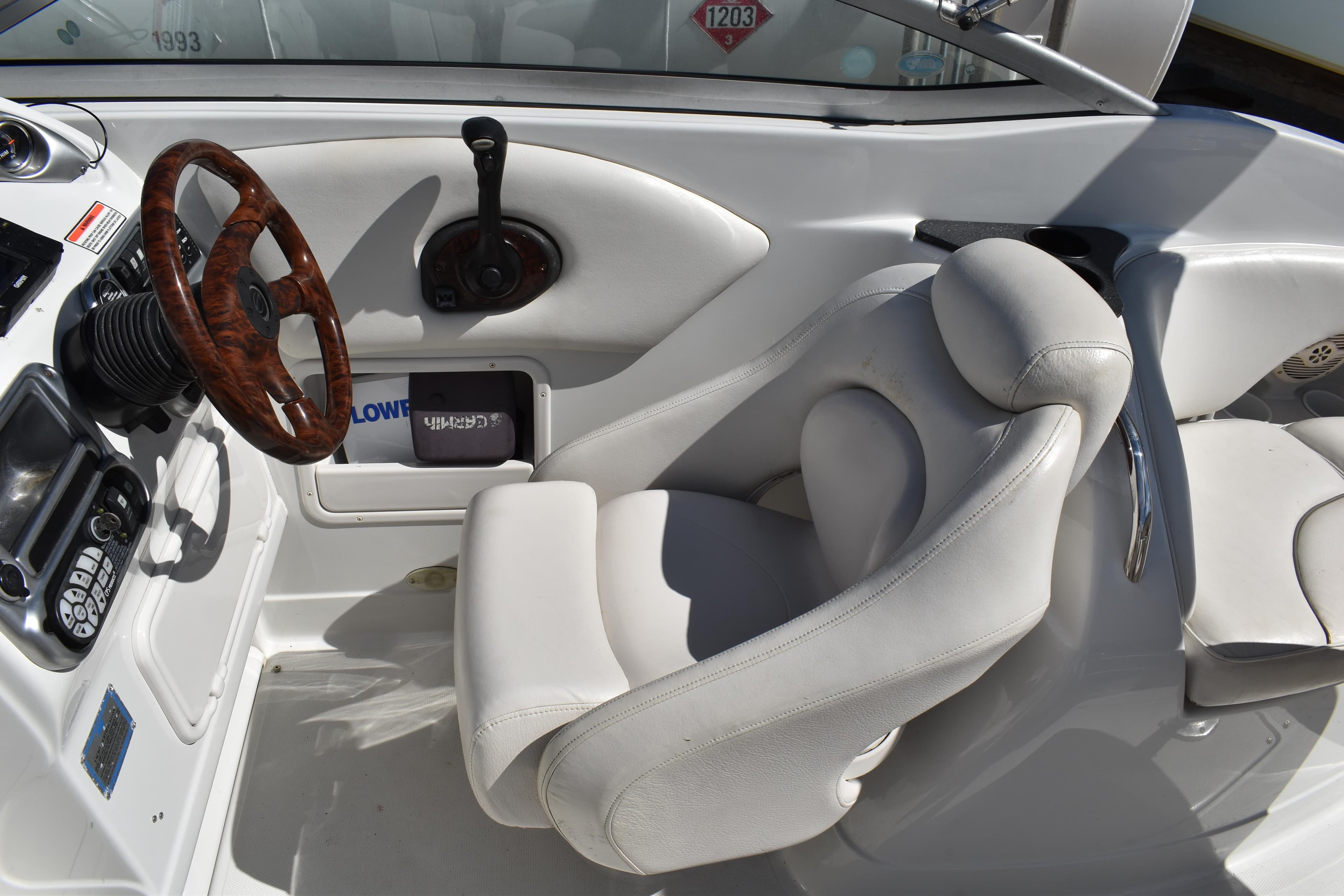 2005 Crownline 275 CCR boat cockpit with white seating and wooden steering wheel.