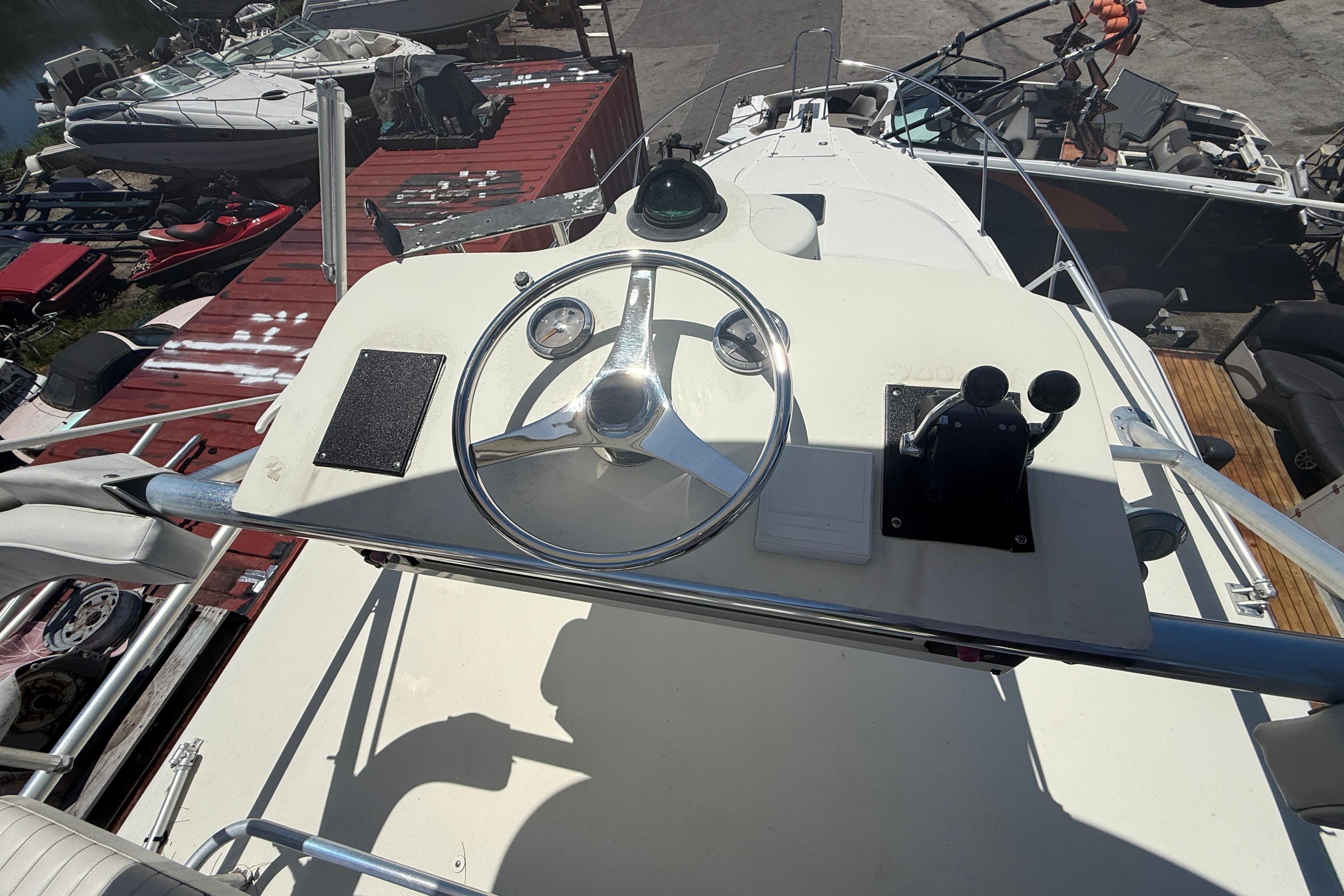 Helm of 2002 Boston Whaler 350 Defiance boat with steering wheel and controls.