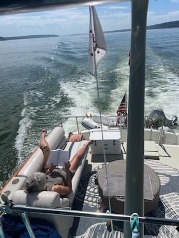 1978 Tollycraft 40 Tri-Cabin MY cruising with passengers relaxing on deck.