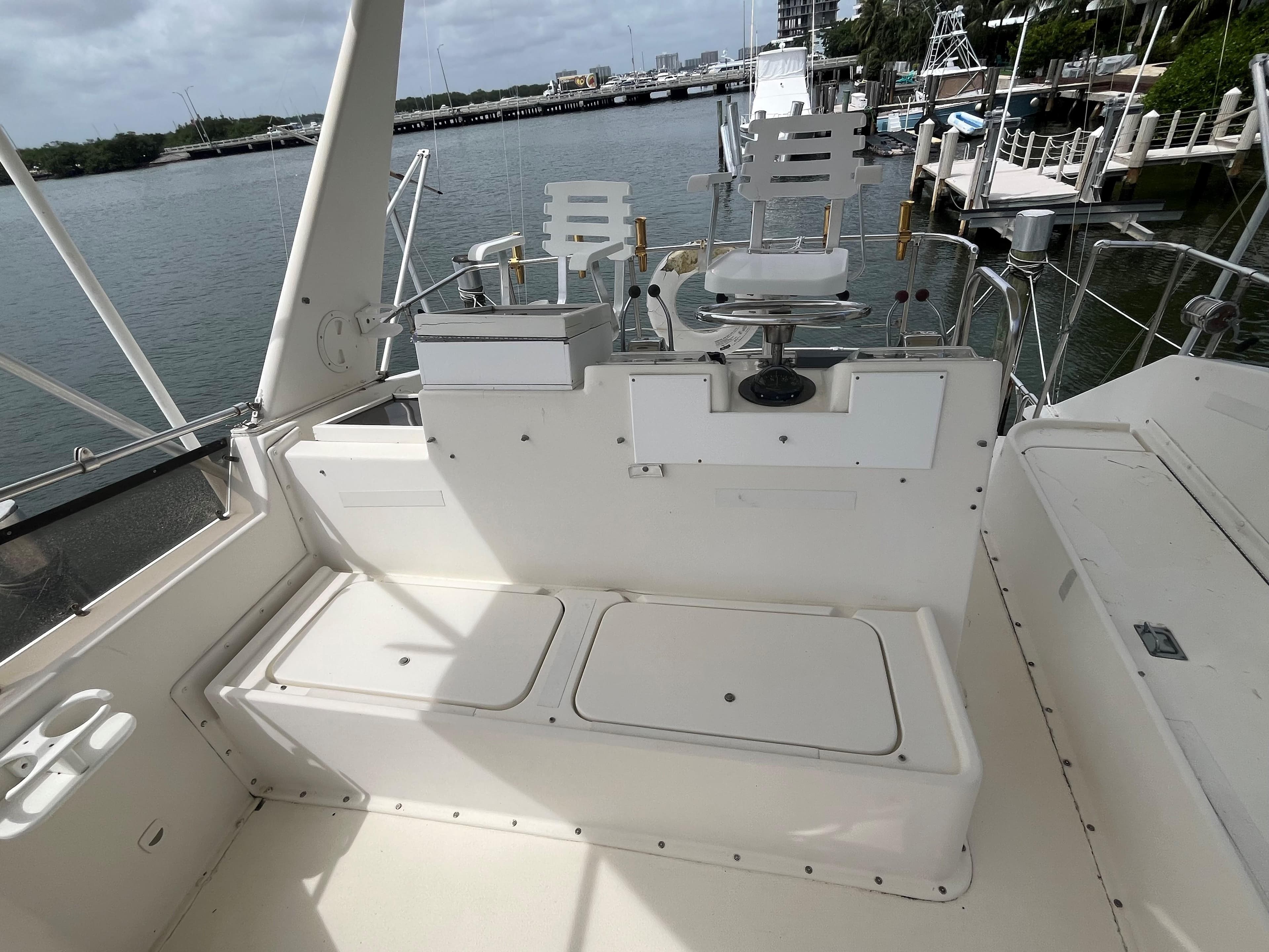 1985 Hatteras 45 Convertible boat deck with seating, overlooking marina.