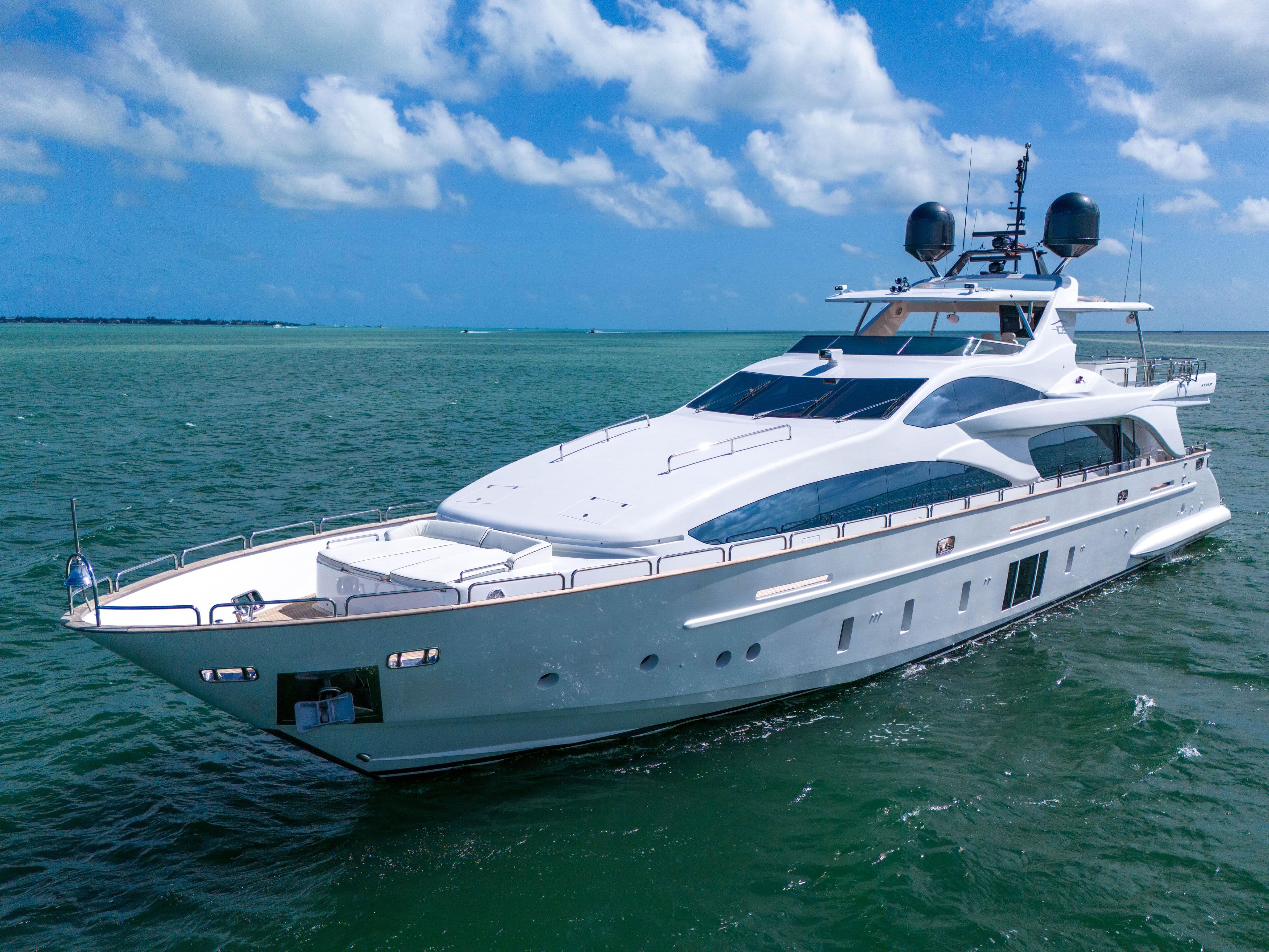 Luxurious 2012 Azimut Grande 105 yacht cruising on clear blue waters under a sunny sky.