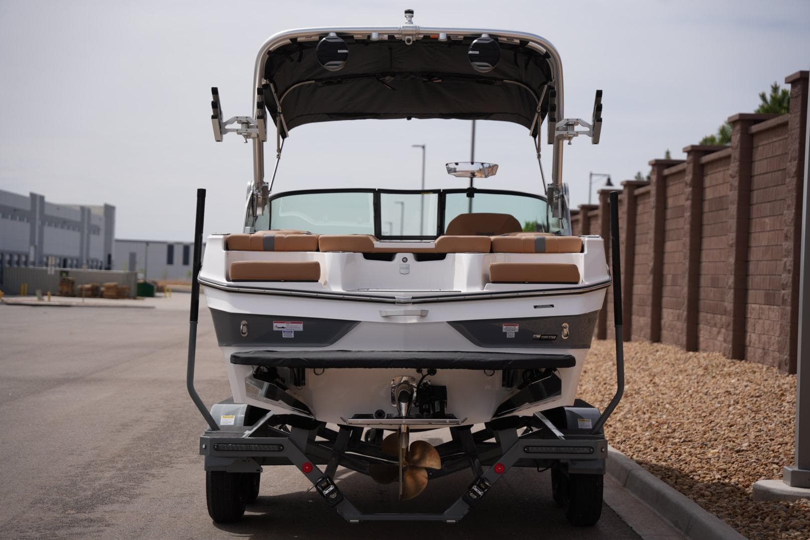 2026 MasterCraft XT20 boat on trailer, rear view, parked near brick wall.