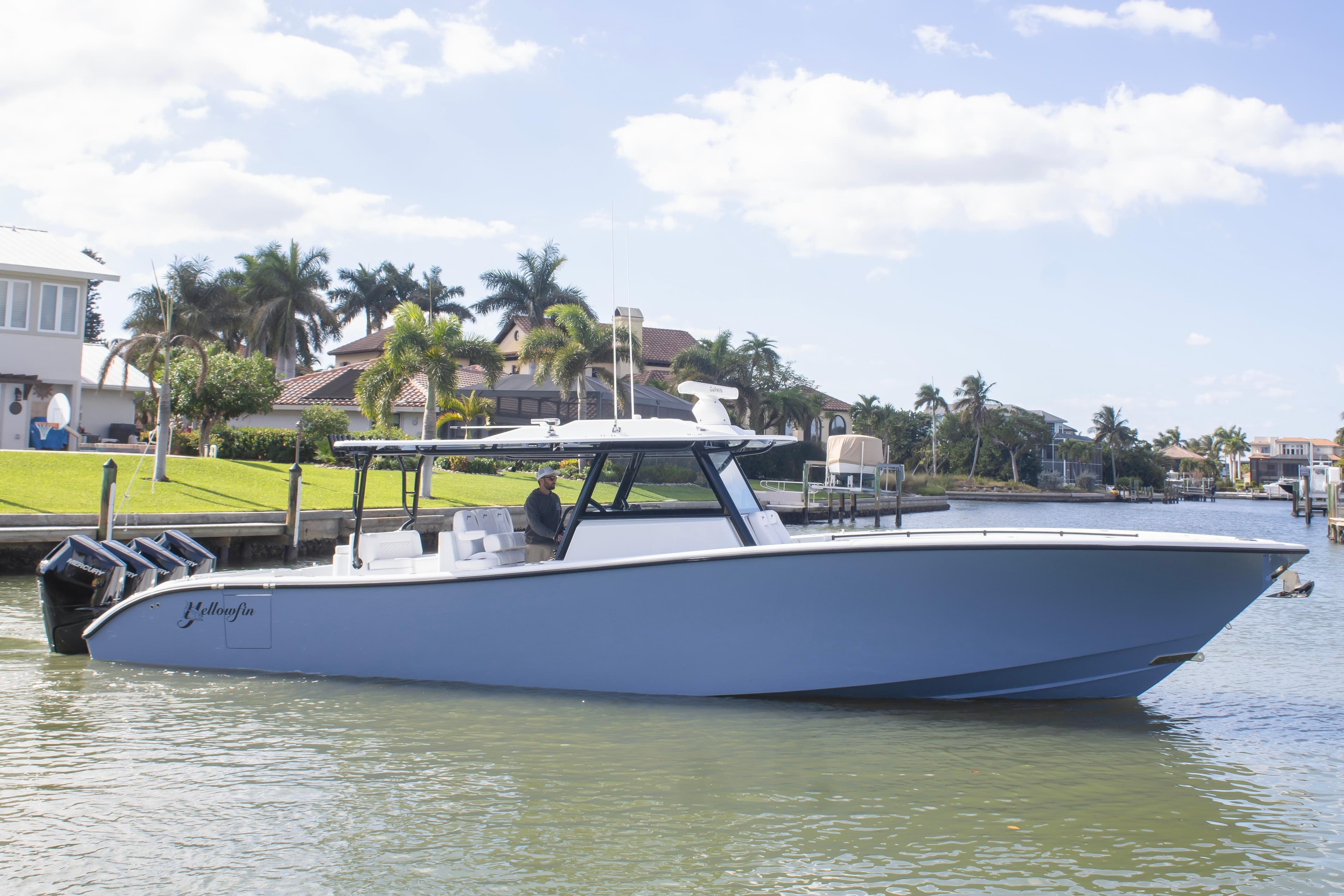 2026 Yellowfin 42 Offshore boat on calm water near luxury homes.