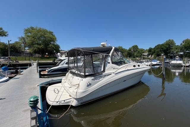 2004 Sea Ray Sundancer 320 docked at marina under clear blue sky.