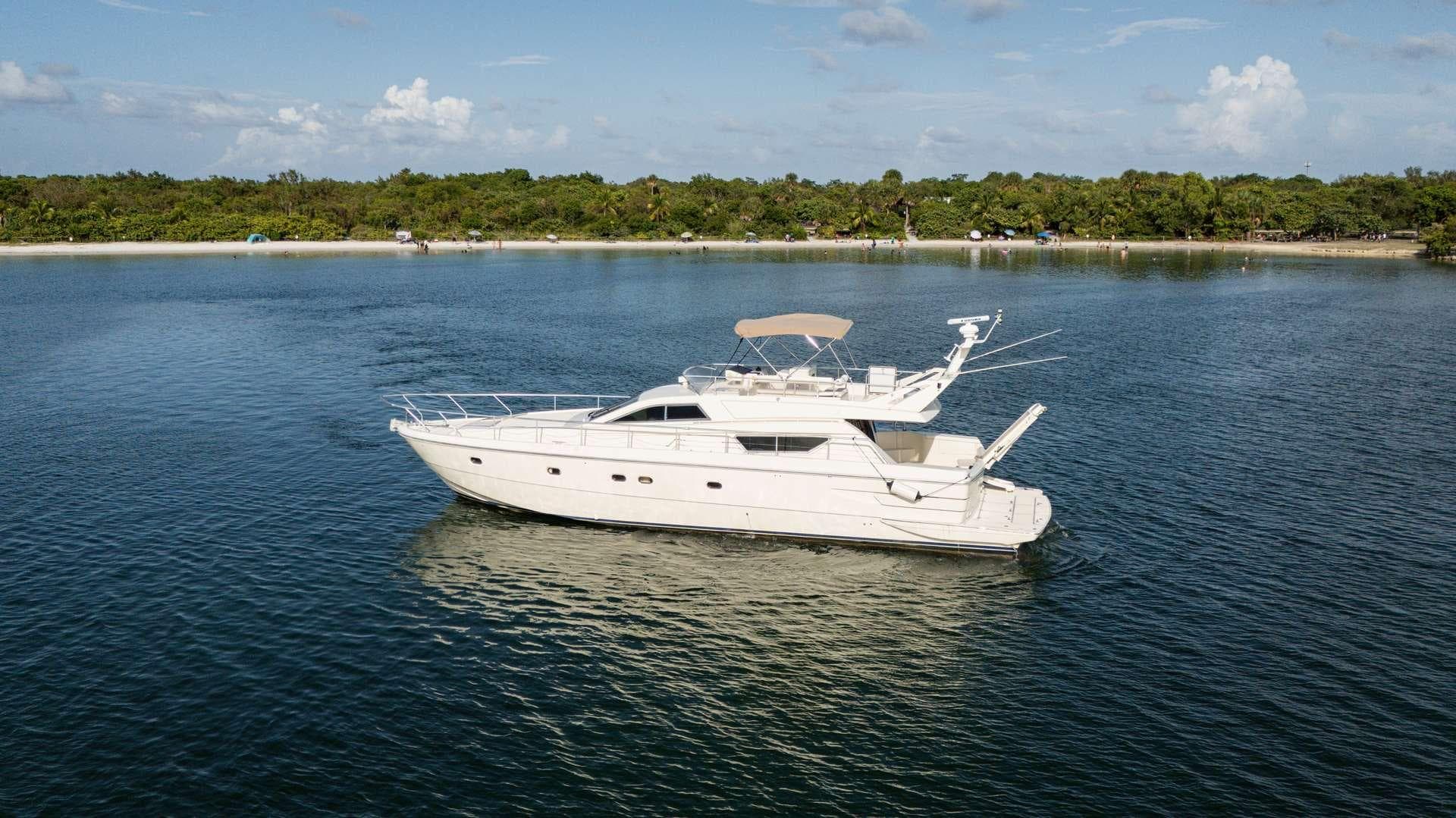 1998 Ferretti Yachts 55 Motor Yacht on calm water near a lush shoreline.