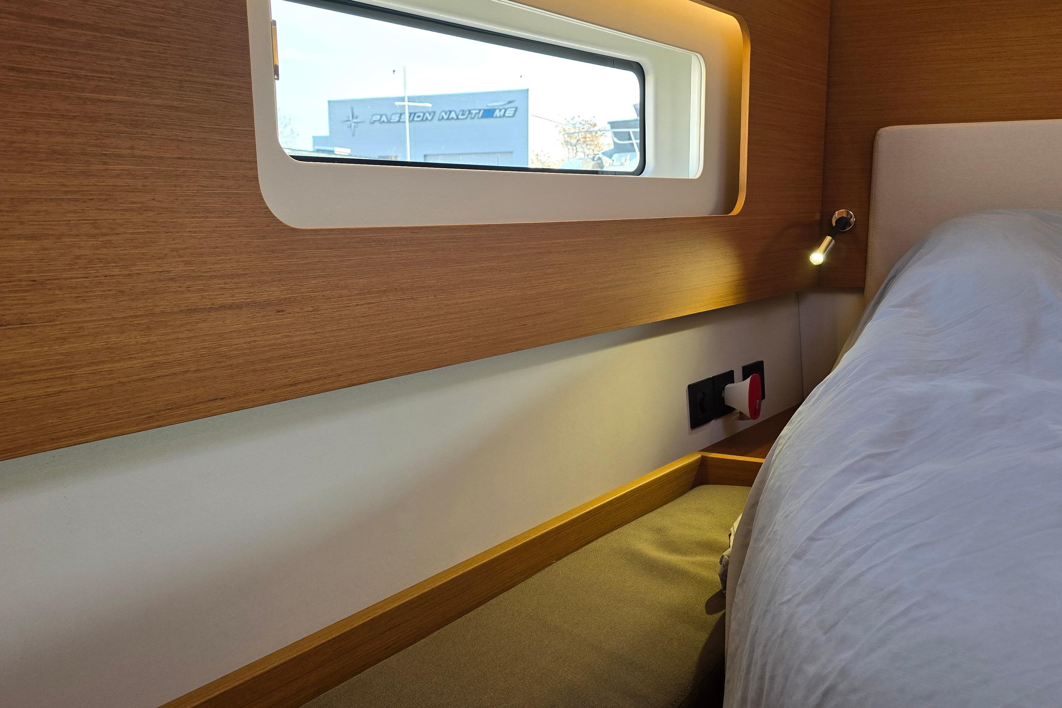 Luxurious interior cabin of 2022 Beneteau First 53 yacht with modern wood finish.