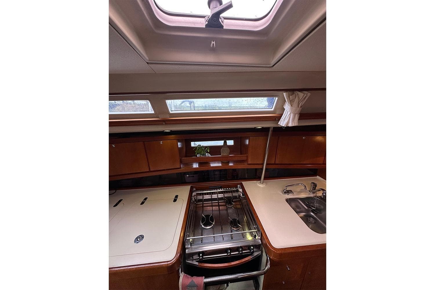 Interior of 2007 Dufour 455 GL yacht kitchen with stove, sink, and overhead windows.