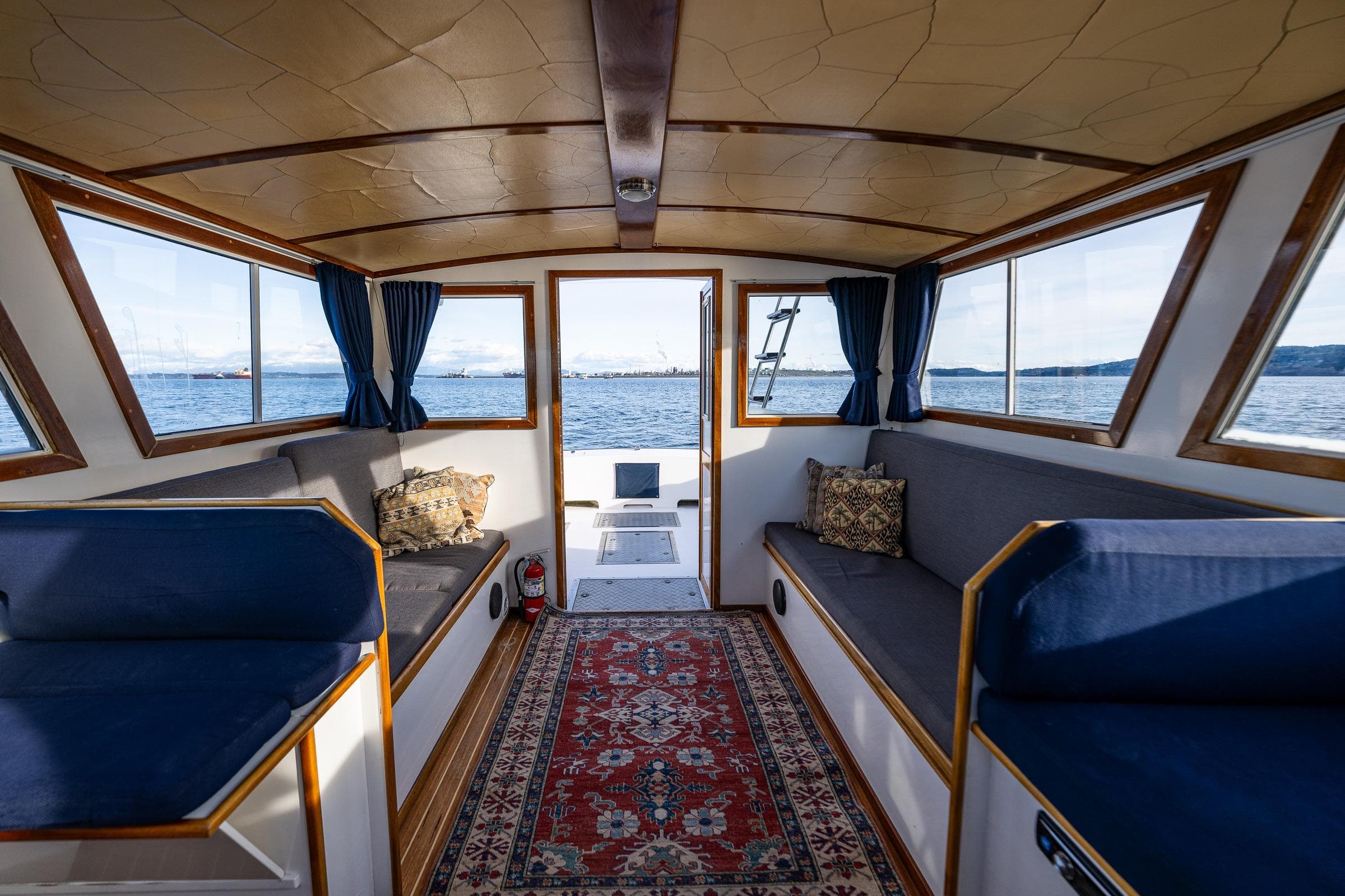 Interior of a 1999 Northern Bay 36 boat with cozy seating and scenic water views.