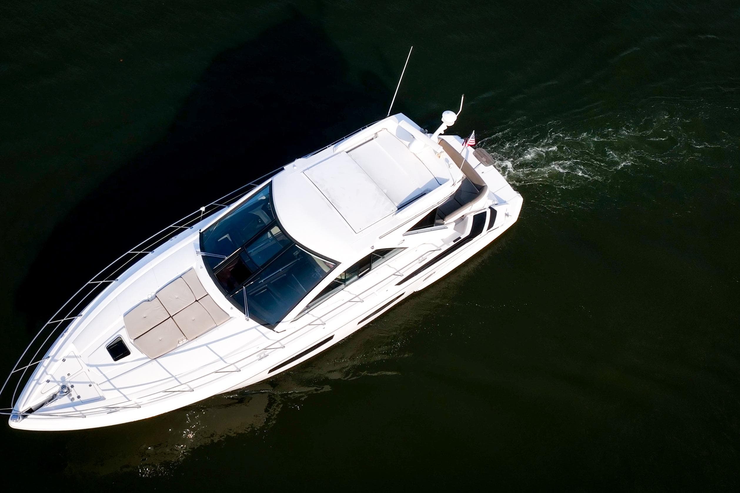 Aerial view of 2015 Regal 53 Sport Coupe yacht cruising on water.