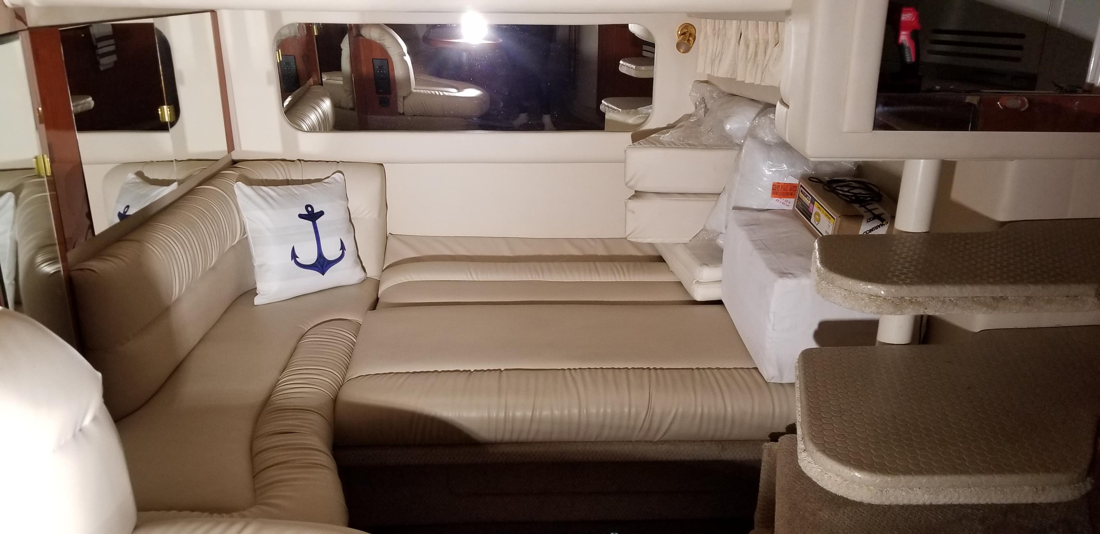 Interior of 1999 Sea Ray 380 Sundancer with beige seating and nautical-themed decor.