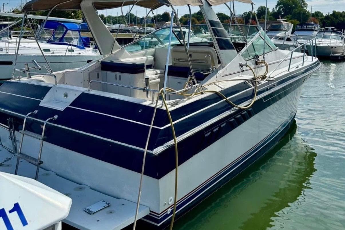 1987 Wellcraft 3400 Gran Sport boat docked in a marina, featuring sleek design and spacious deck.
