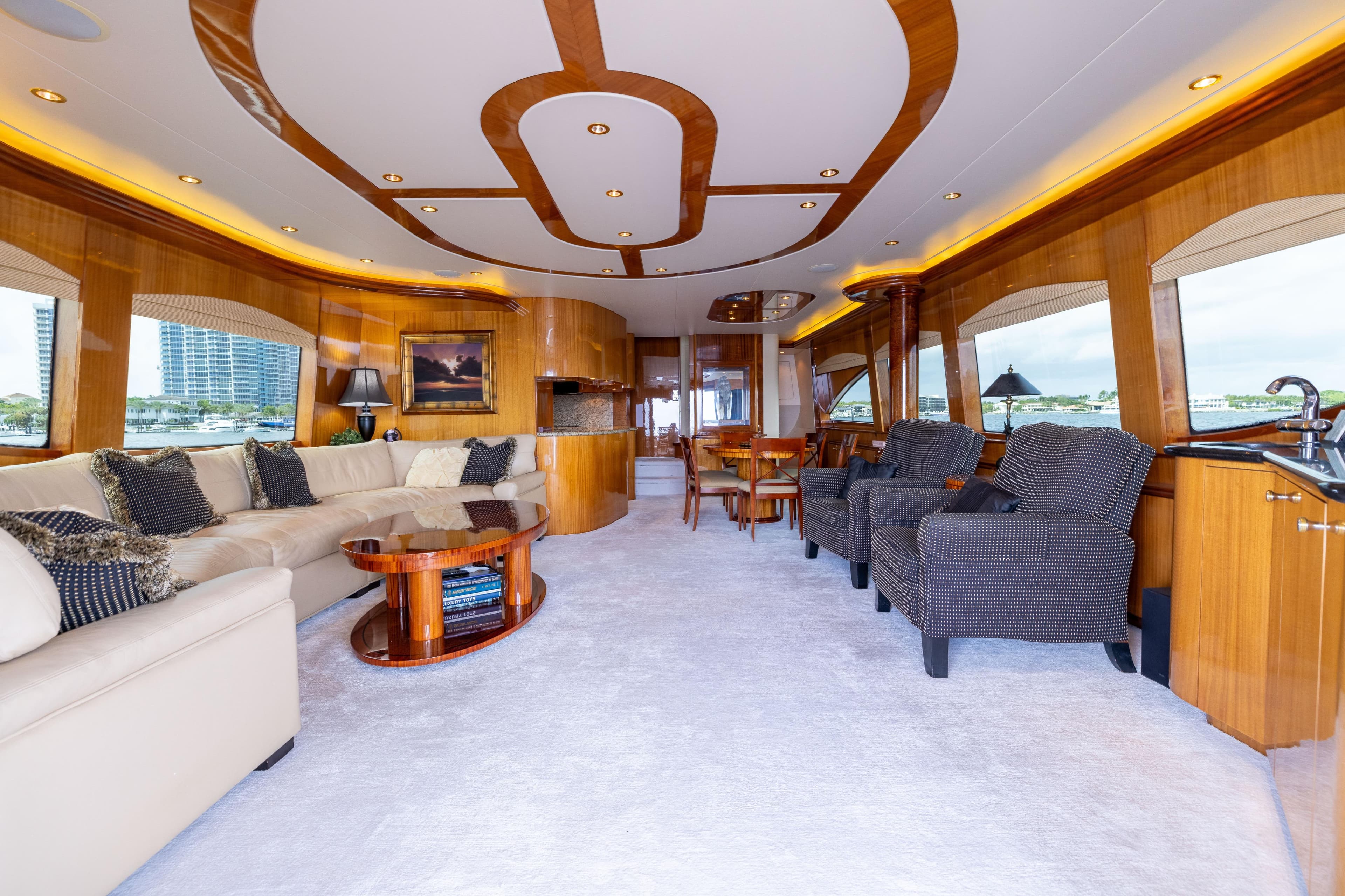 Luxurious interior of 2005 Hatteras 80 Motor Yacht with elegant seating and wood accents.