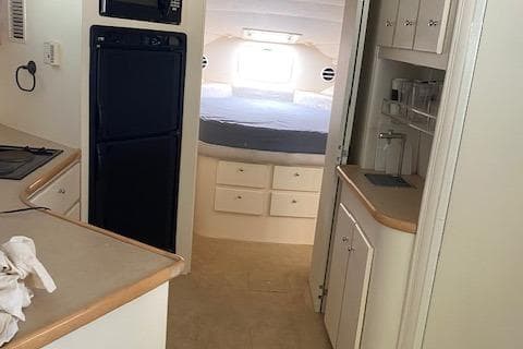 Interior of 1998 Carver 380 Santego yacht, featuring kitchen and cozy sleeping area.