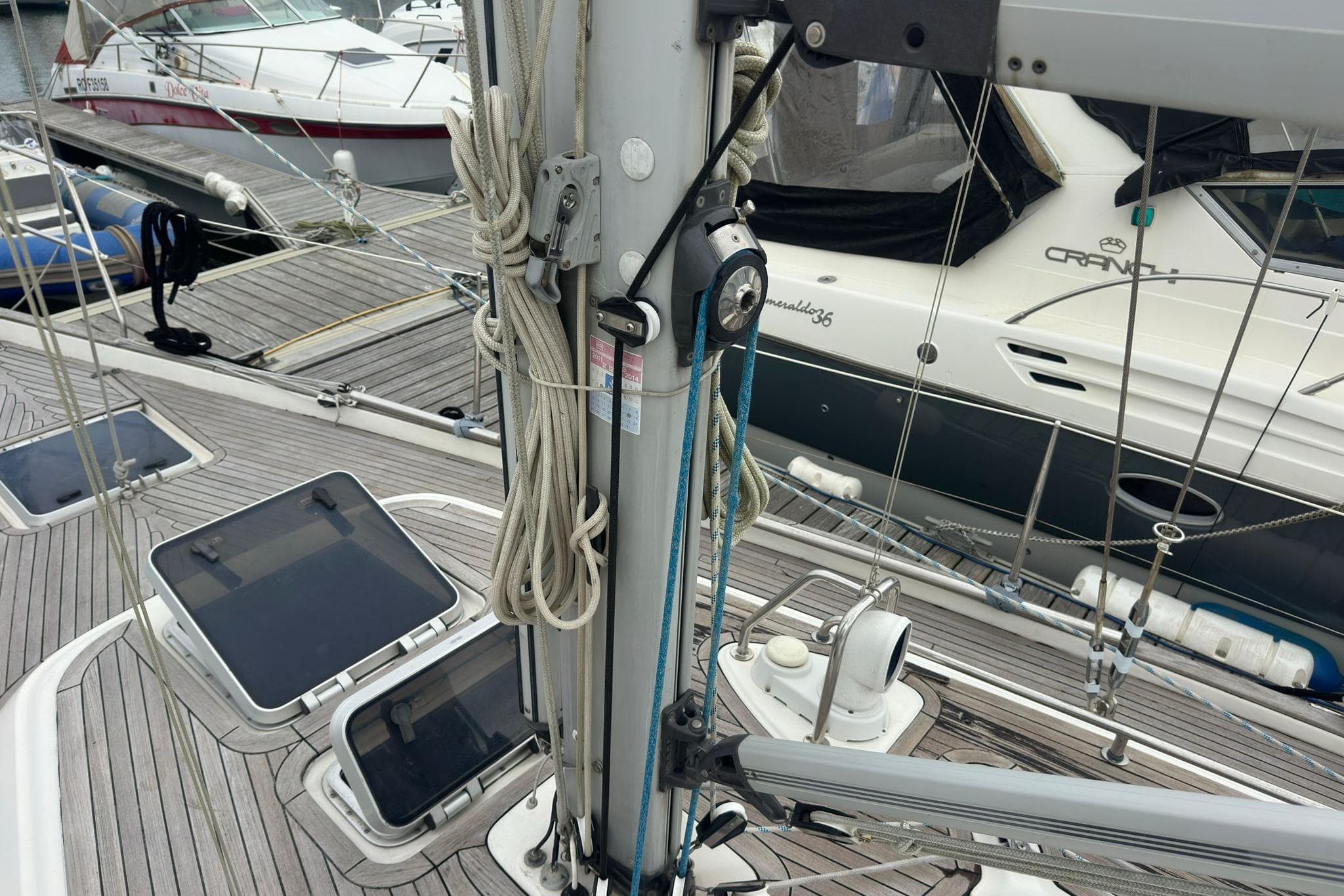 Deck view of a 1999 Bavaria Yachts 38 Ocean sailboat in a marina.