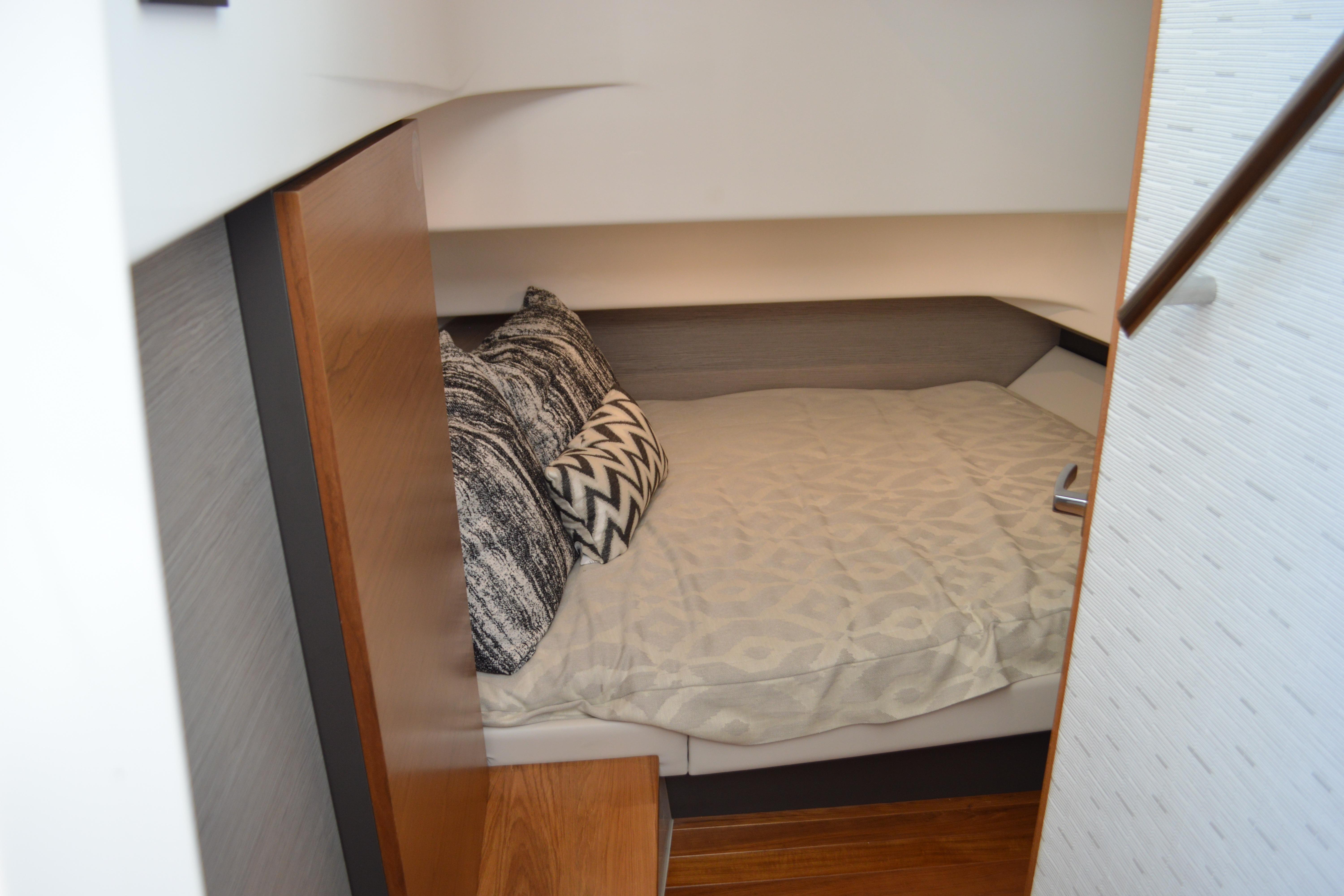 Cozy cabin interior of 2024 Tiara Yachts 34 LS with stylish bedding and pillows.