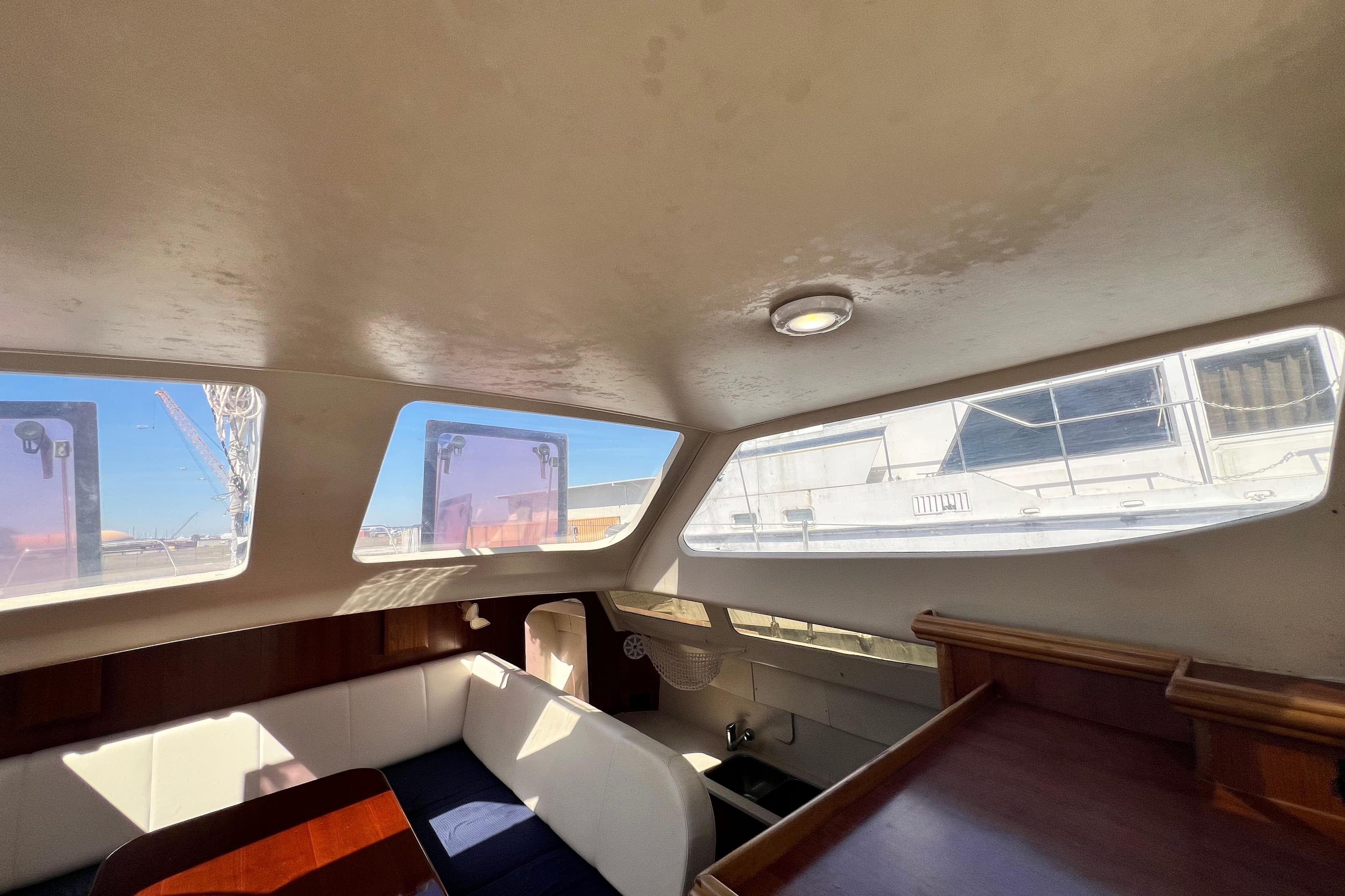 Interior of 2013 Gemini Legacy 35 sailboat with large windows and seating area.
