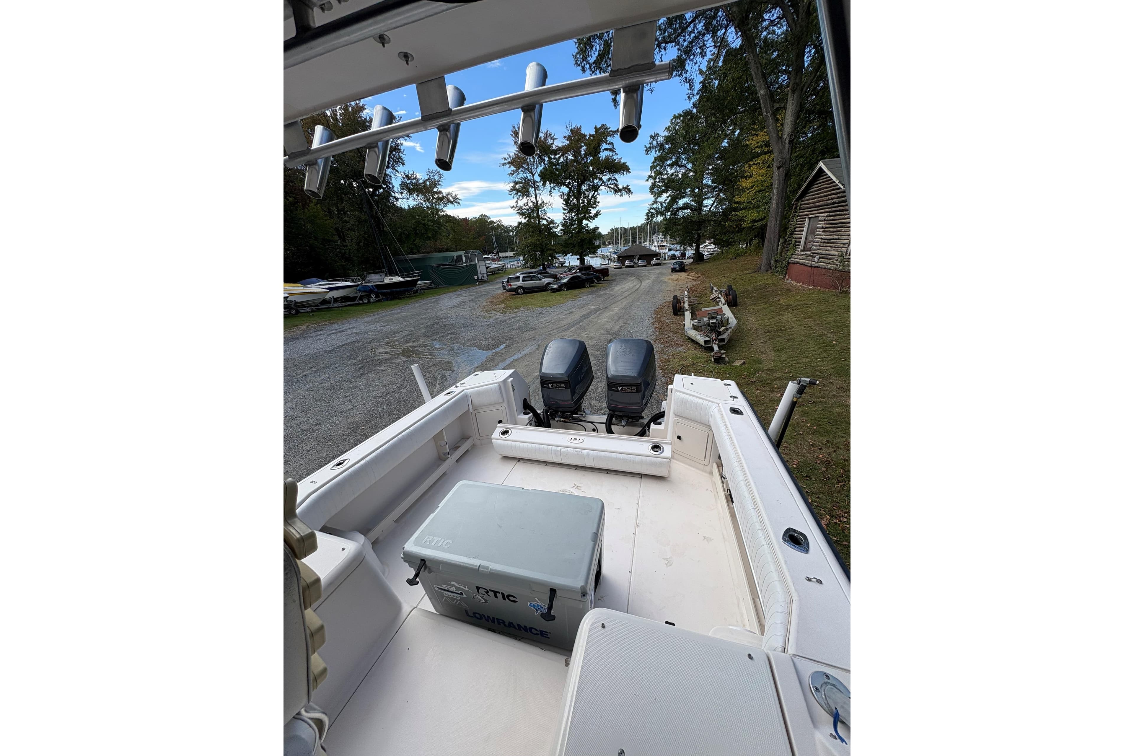 2001 Grady-White Express 265 boat with twin engines, parked near a wooded area.