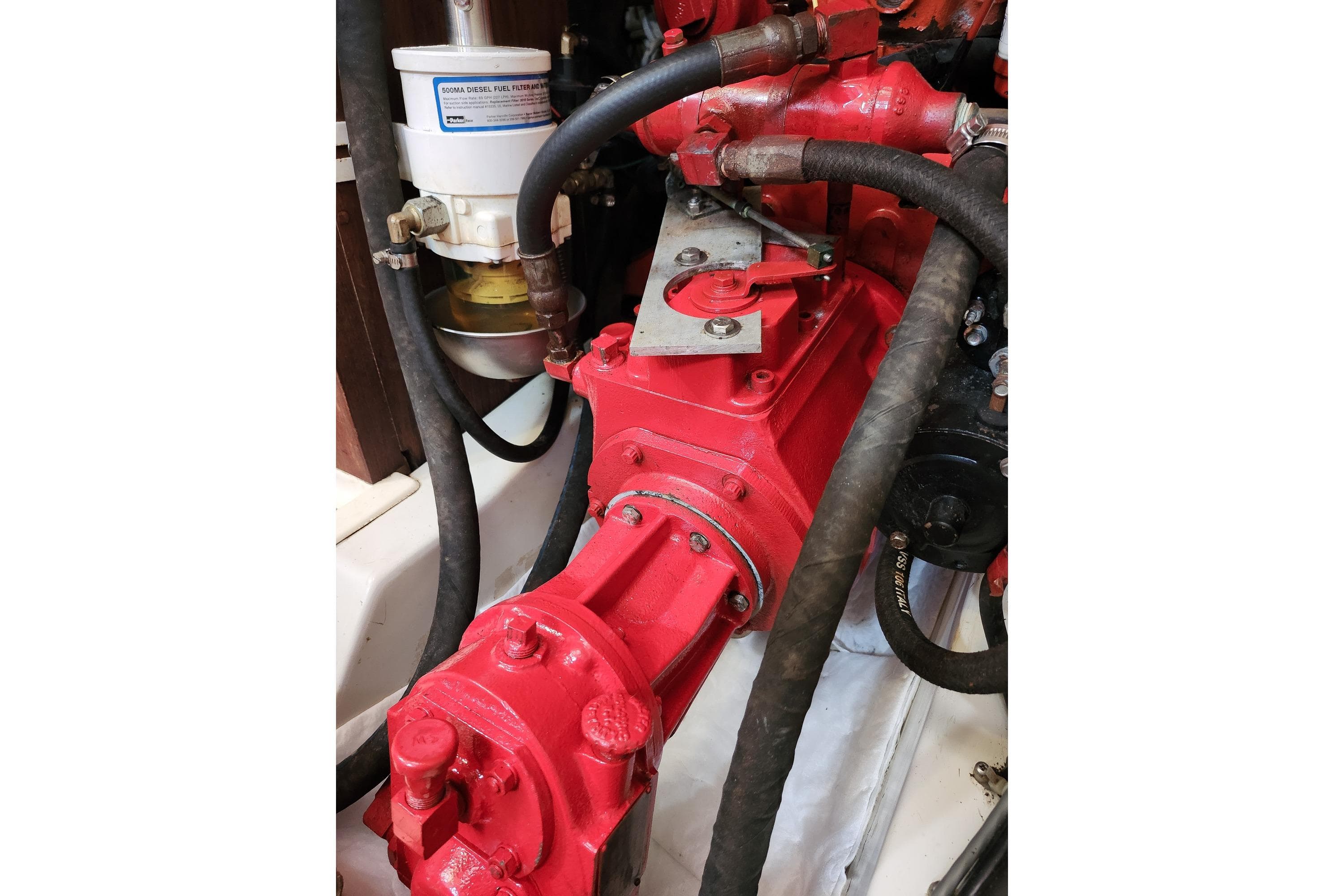 Engine compartment of 1982 Canadian Sailcraft CS 36 sailboat, featuring red machinery and fuel filter.