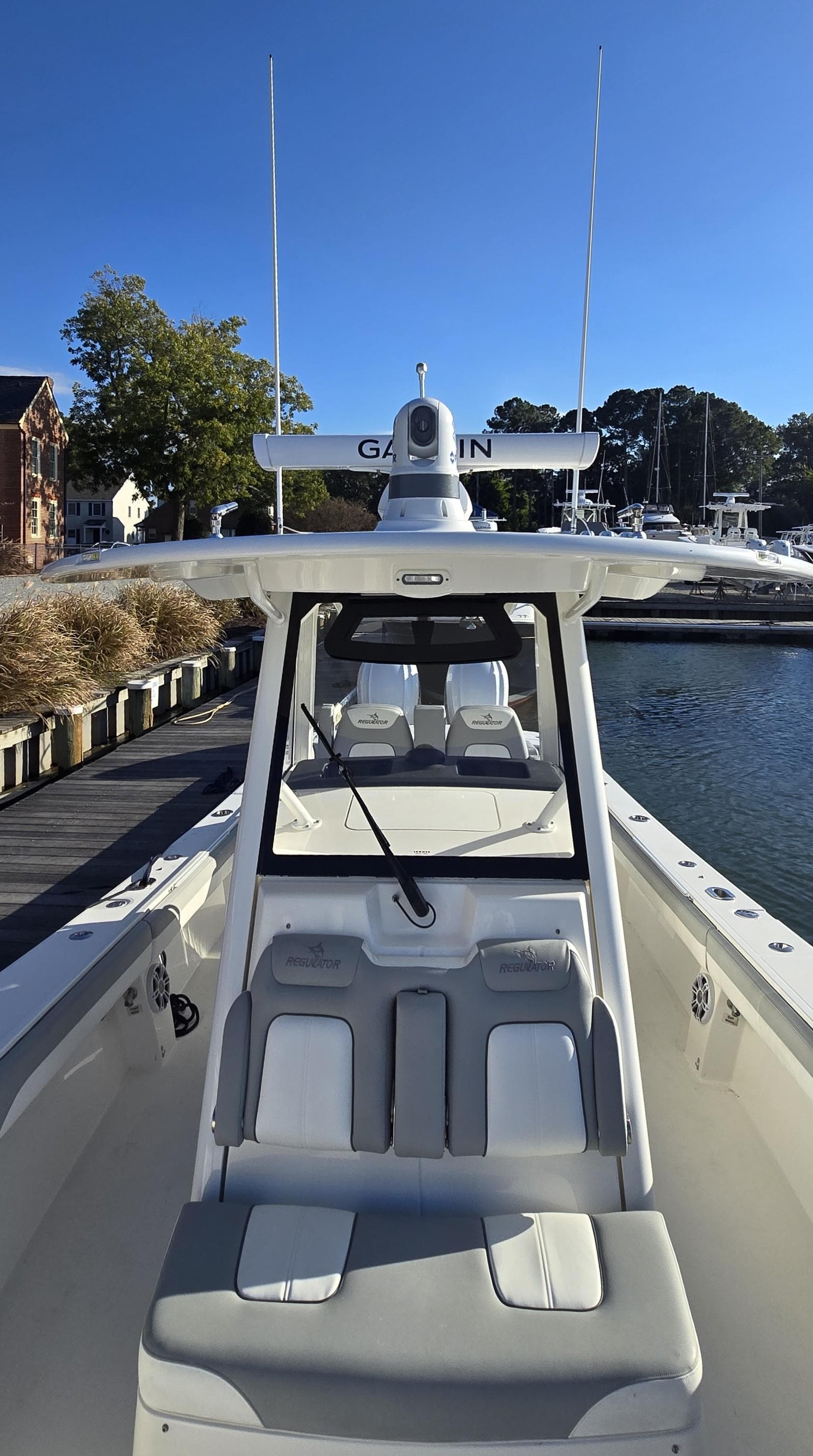 2021 Regulator 34 Center Console boat docked in a marina under clear blue skies.
