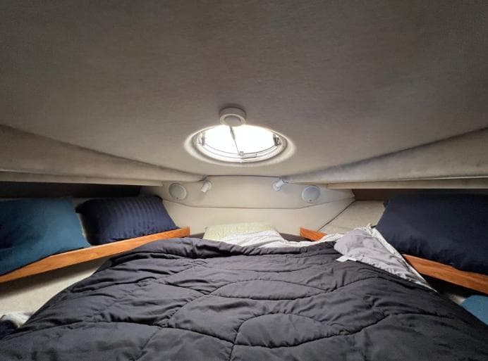 Cozy cabin interior of 1997 Bayliner 3788 Command Bridge Motoryacht with bed and porthole.