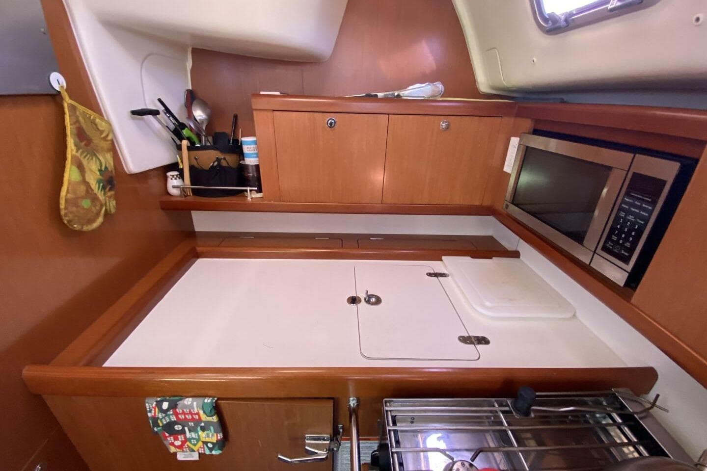 Galley kitchen in 2009 Beneteau 43 yacht with microwave and storage cabinets.