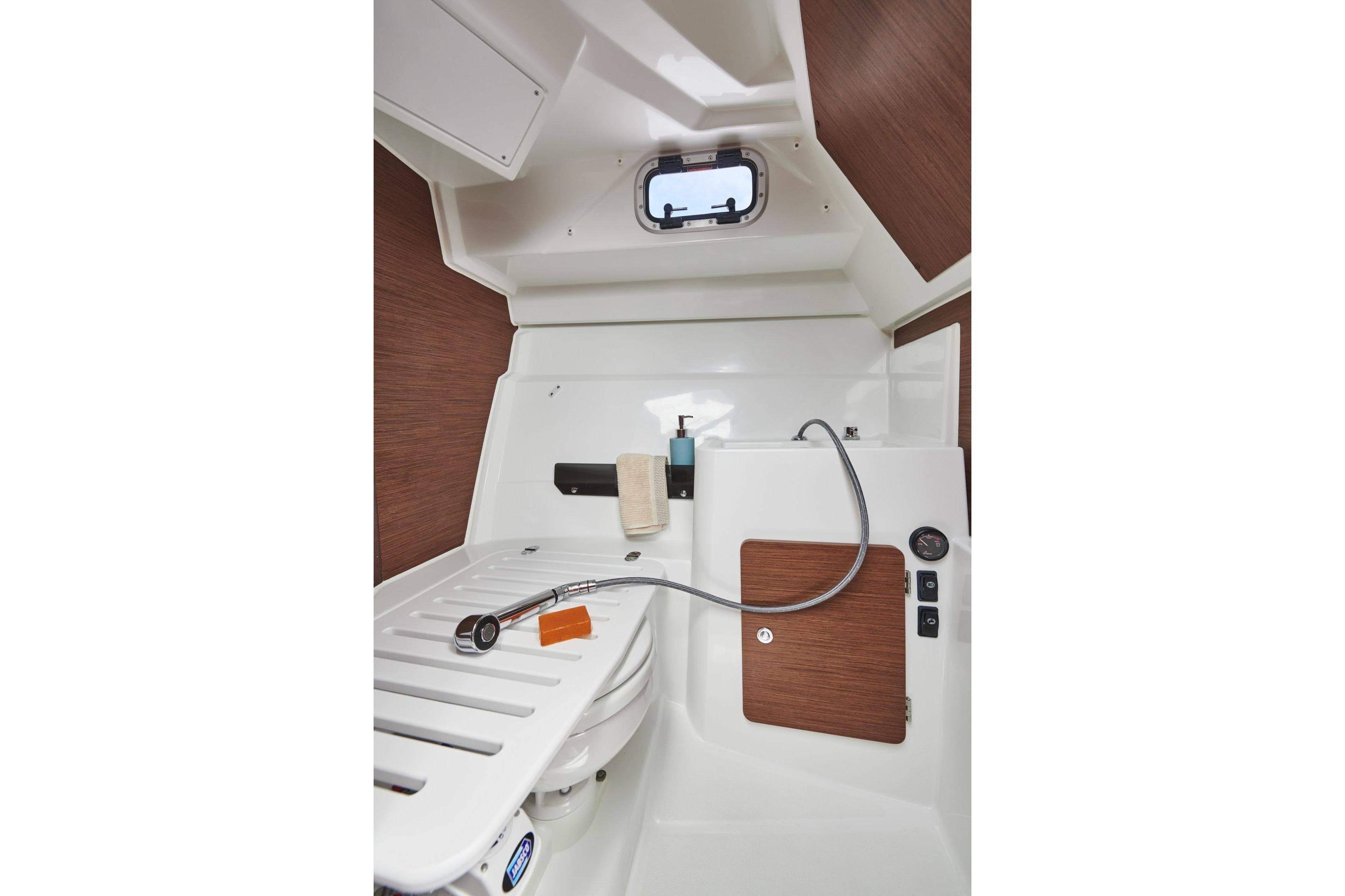 Interior of 2026 Jeanneau NC 795 Series 2 boat bathroom with shower and window.