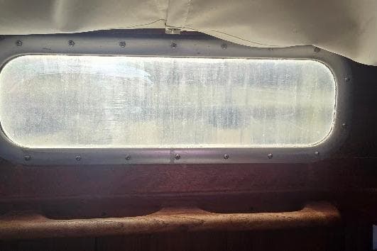 Porthole view from 1978 Tartan T34c sailboat, showcasing vintage nautical design.