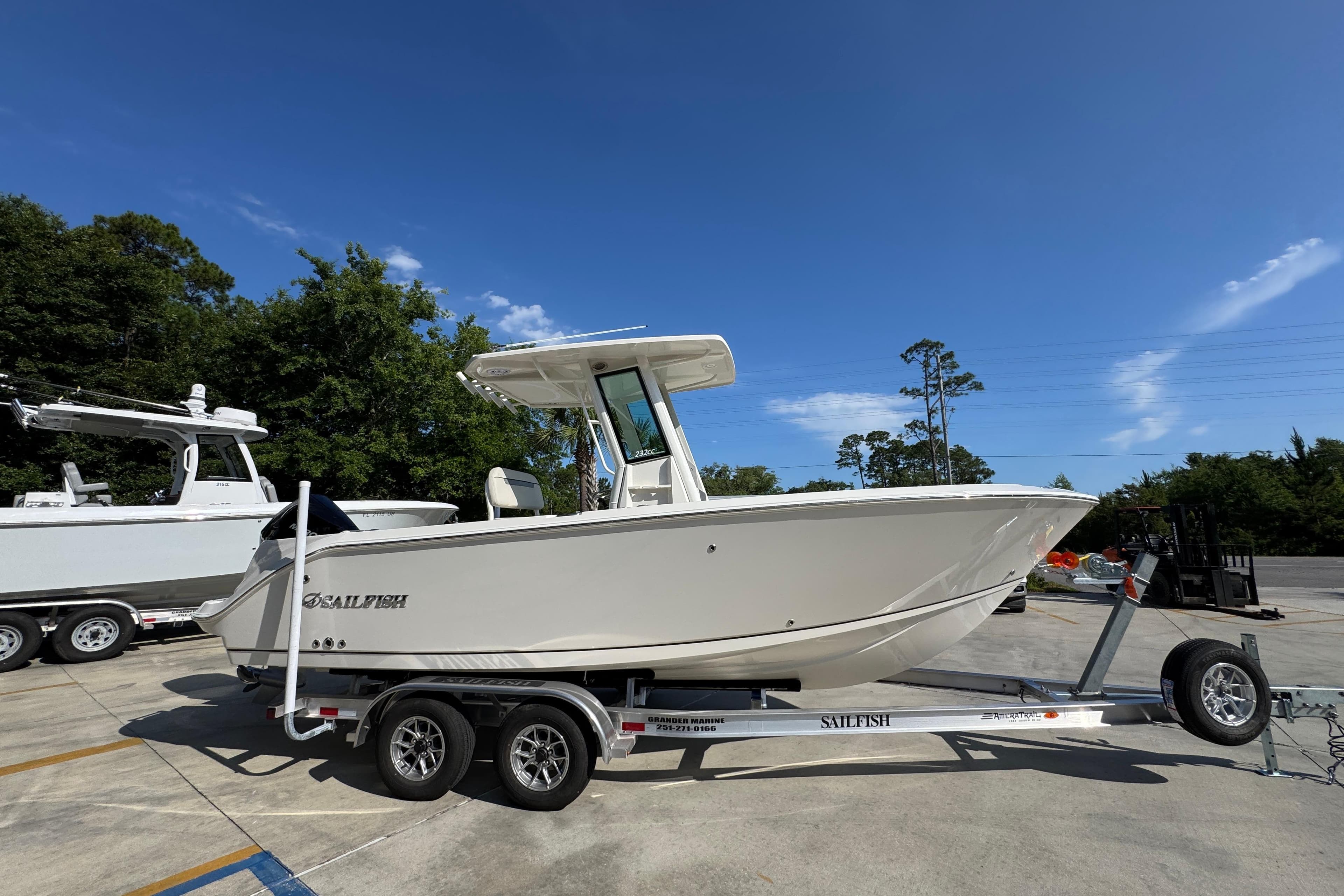 2026 Sailfish 232 CC boat on trailer, parked outdoors under clear blue sky.