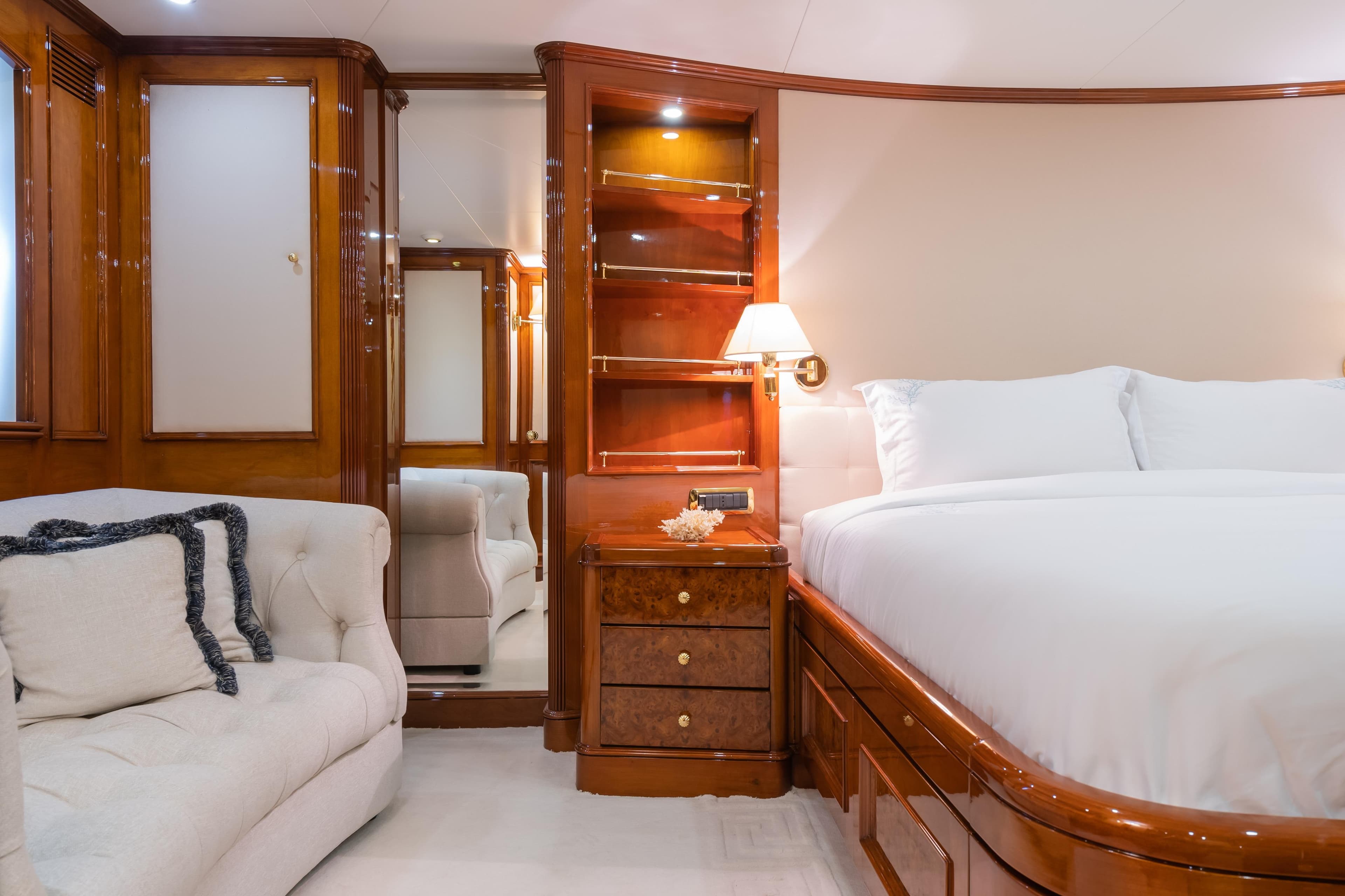 Luxurious 1998 Benetti Classic yacht bedroom with elegant wood finishes and plush bedding.