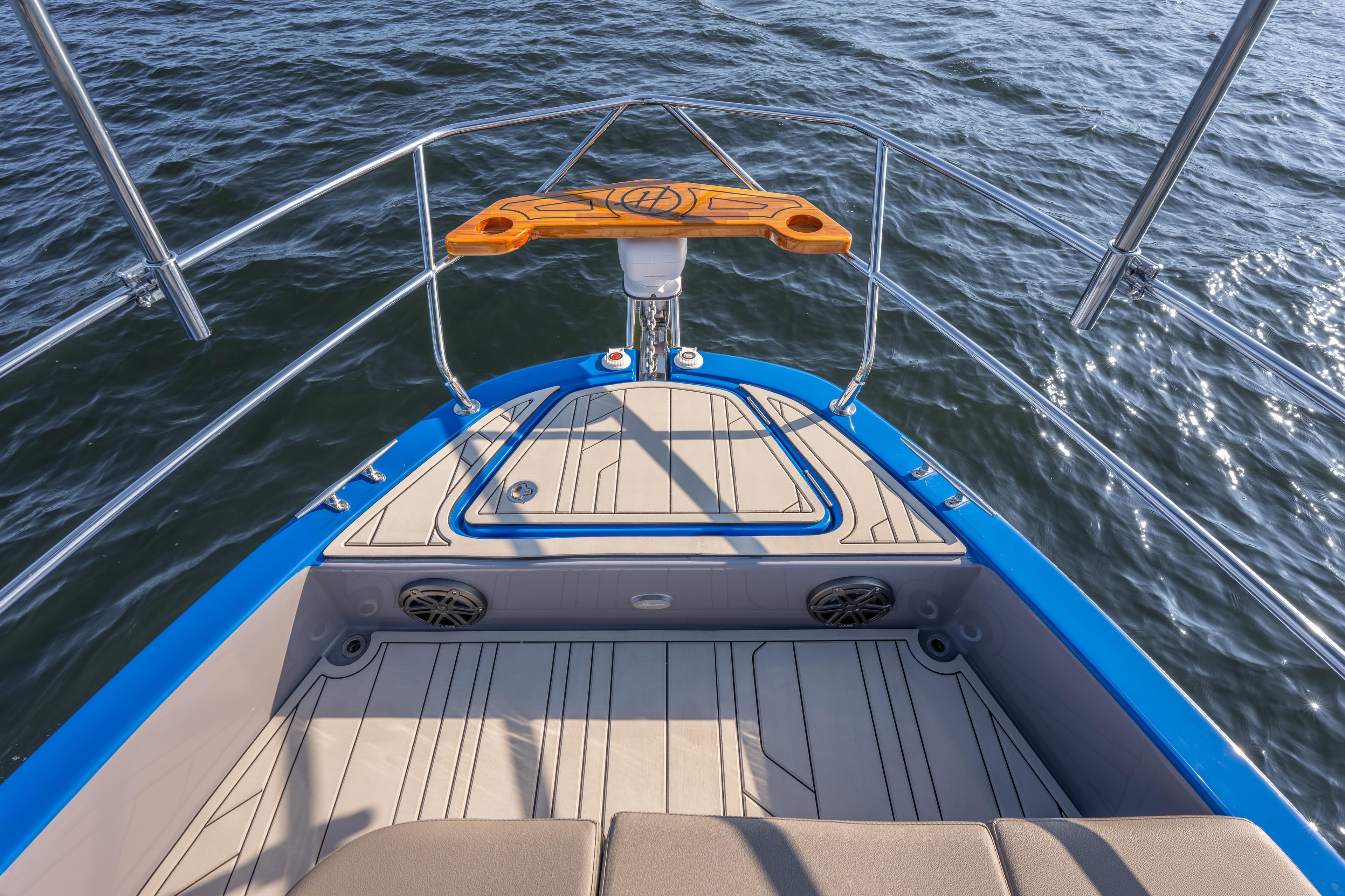Bow view of 2026 Hanover 347 boat with sleek design and blue accents on water.