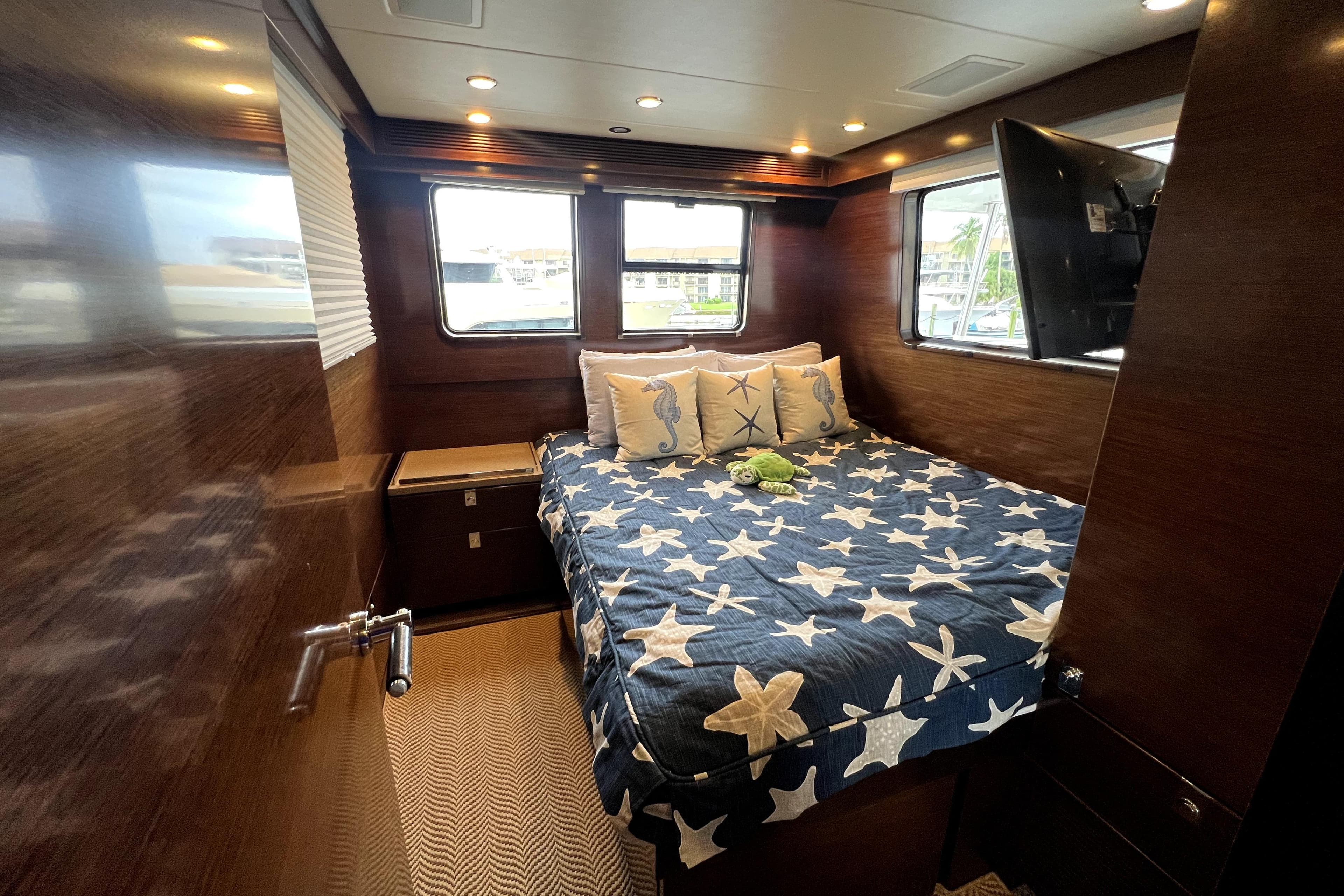 Luxurious cabin interior of 2009 Nordhavn N78 yacht with starfish-themed bedding.