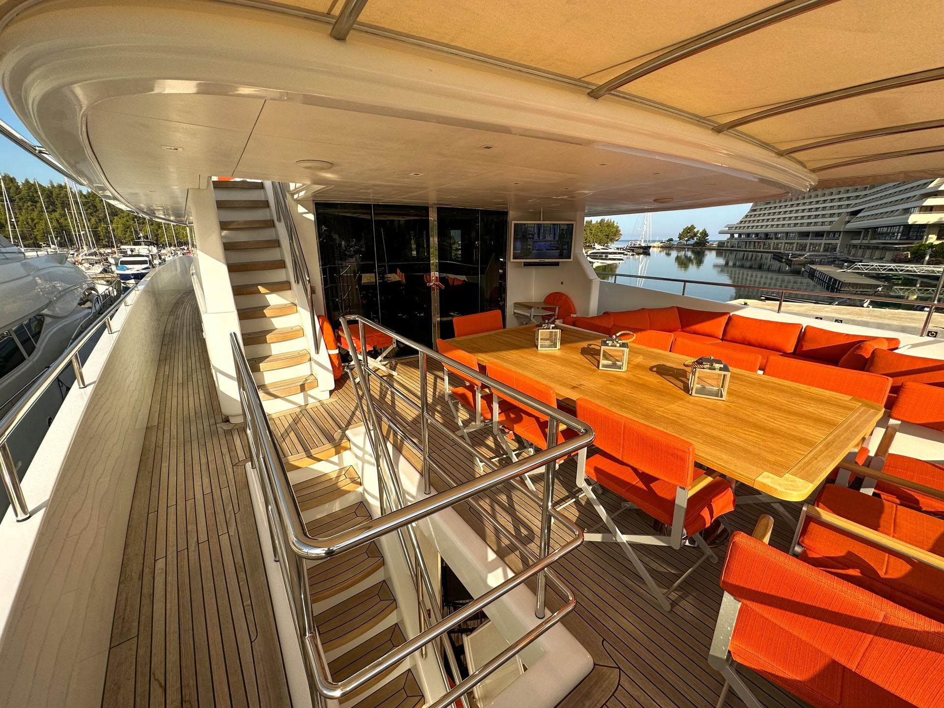 Luxurious deck of 2012 Custom Avangard Yachts 42M with orange seating and wooden table.