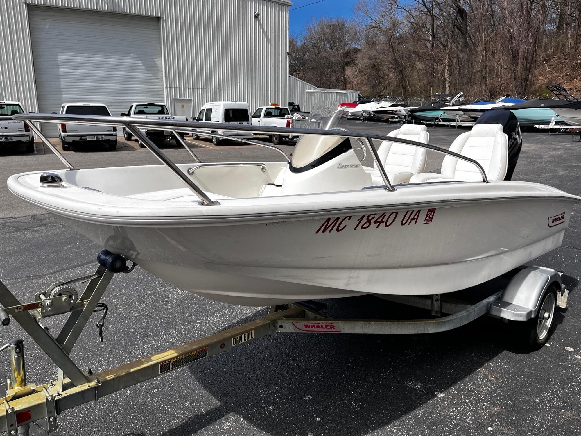 2017 Boston Whaler 130 Super Sport boat on trailer in parking lot.