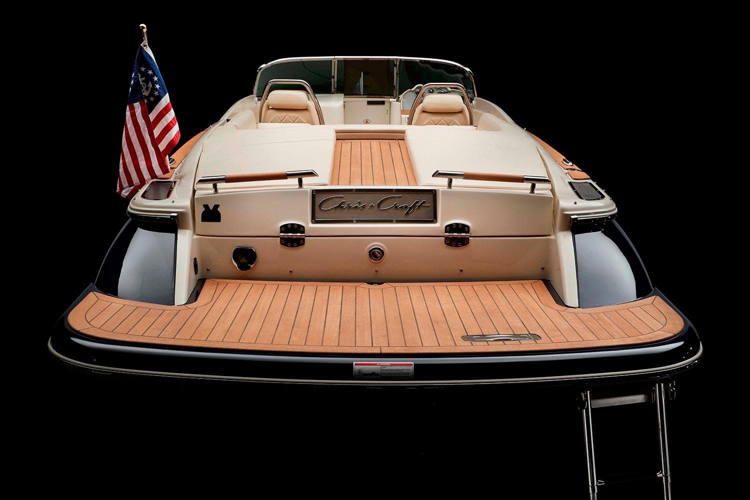 Manufacturer Provided Image: 2025 Chris-Craft Launch 27 boat with American flag, rear view, teak deck.