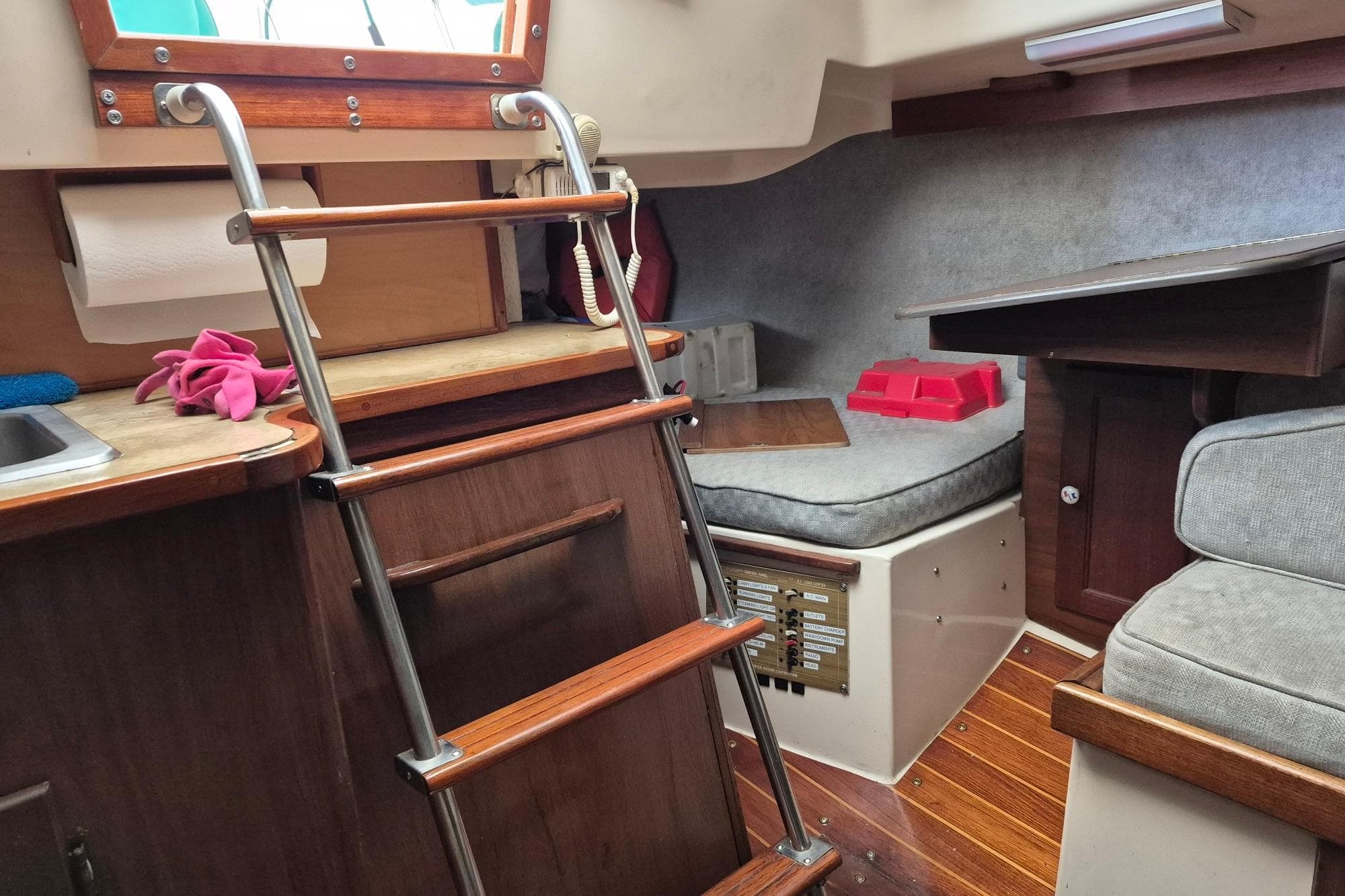 Interior of a 1978 Hunter 30 sailboat with wooden ladder and cozy seating area.