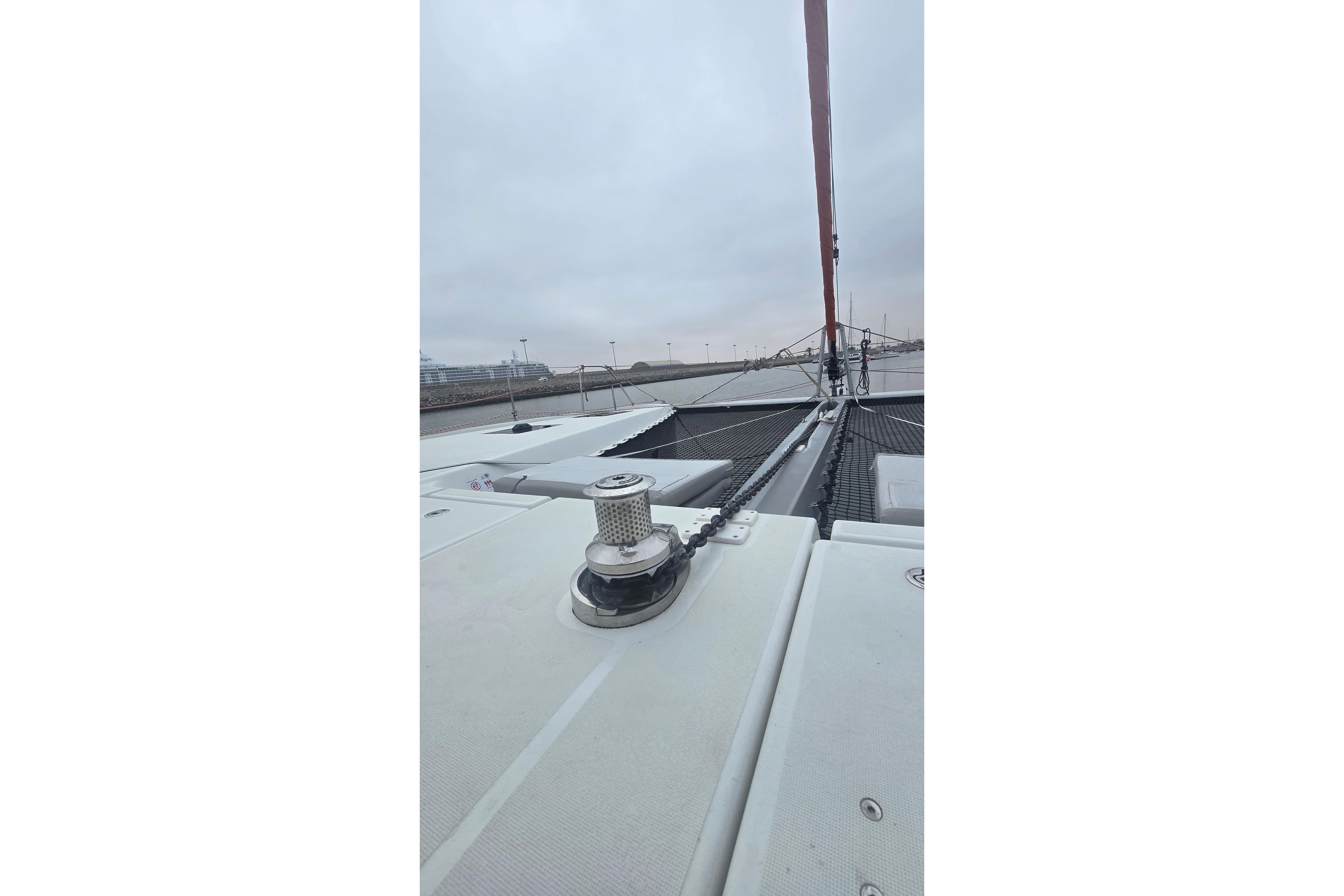 2024 Excess 14 catamaran deck with winch and rigging under cloudy sky.