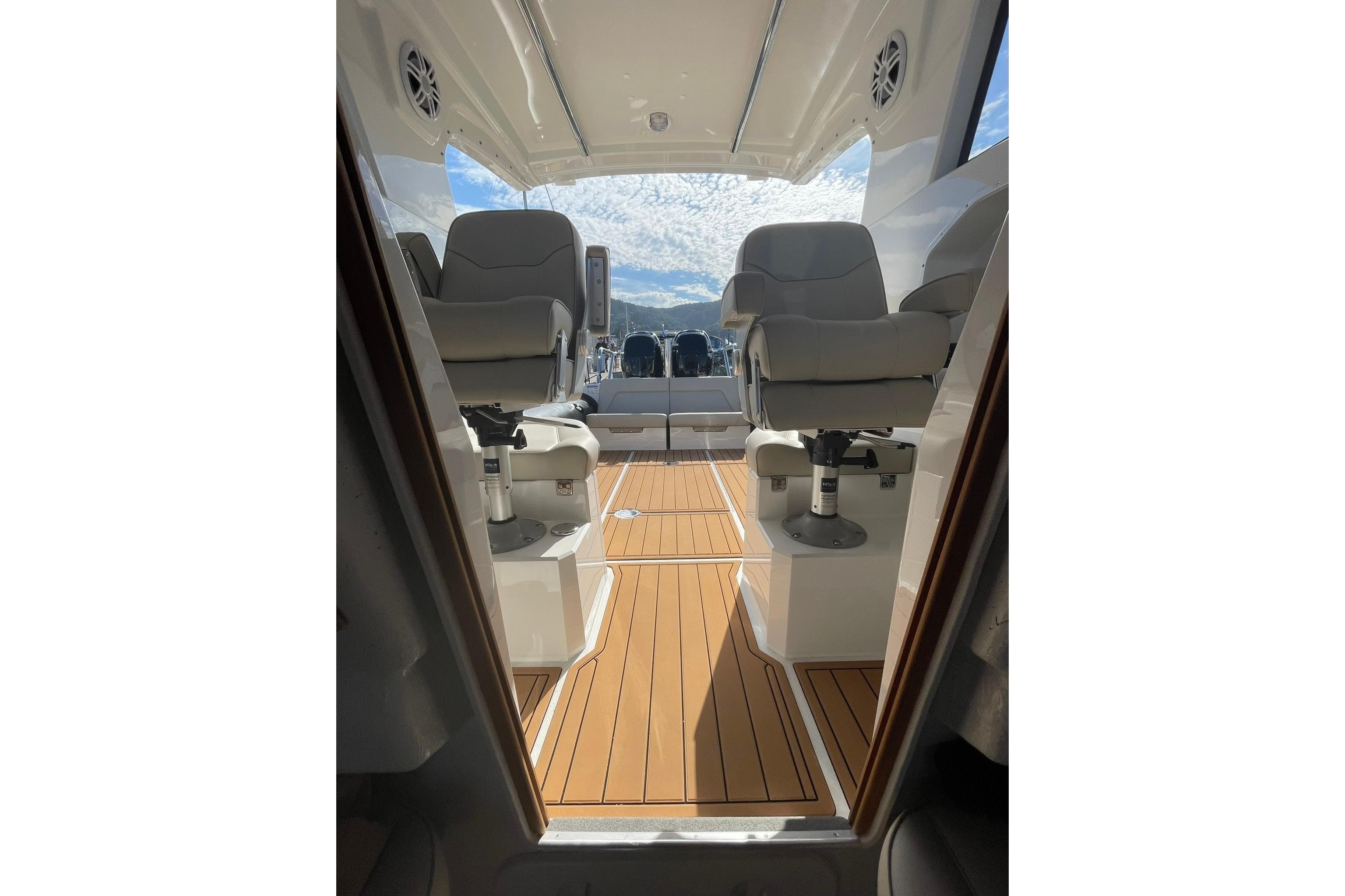 2024 Protector 330 Targa boat interior with twin 400 HP engines, featuring sleek seating and wood flooring.