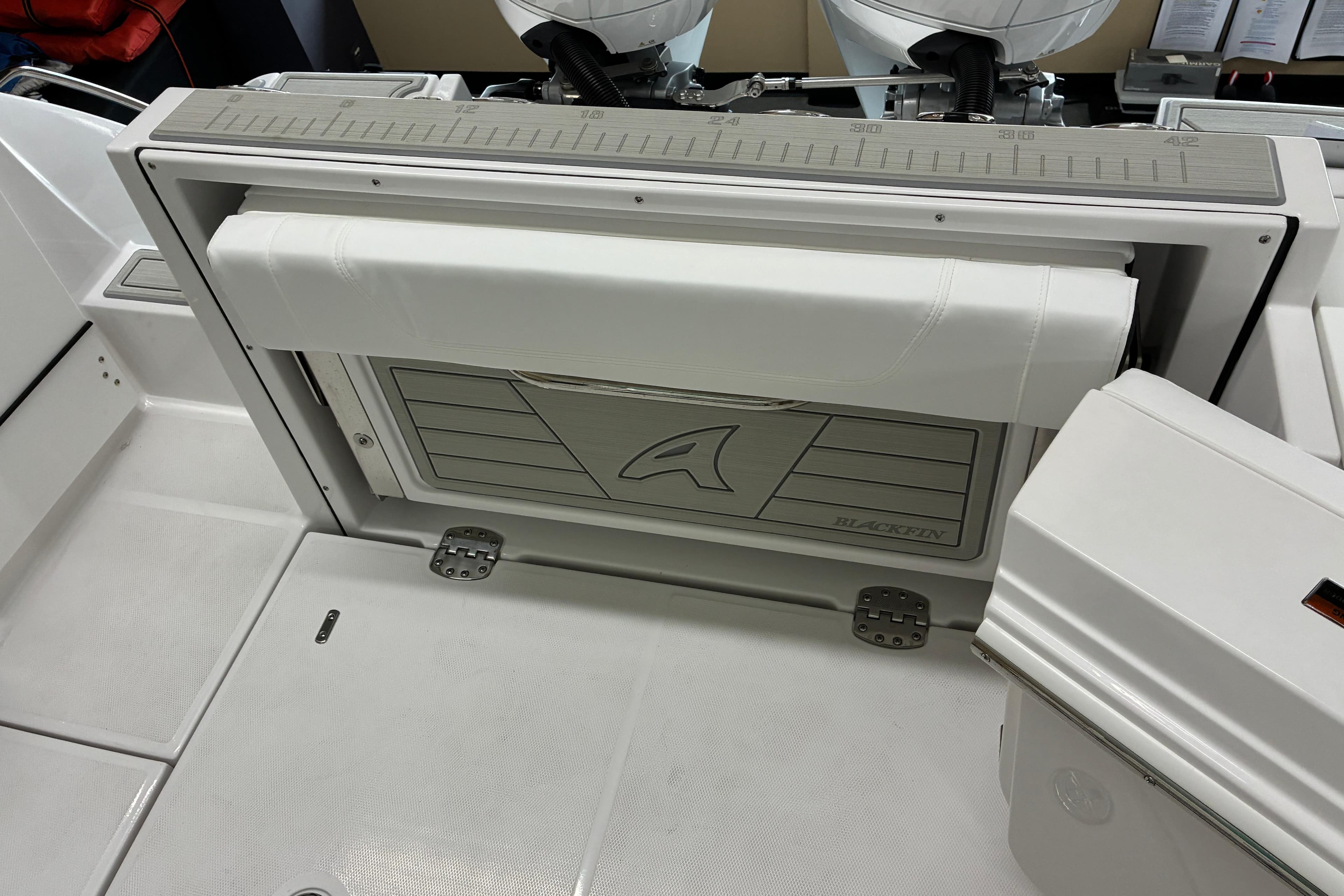 2026 Blackfin 252 CC boat interior with foldable seat and storage compartment.