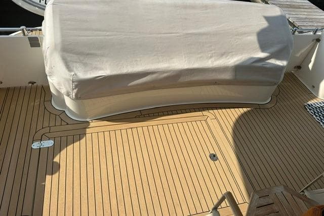 Teak deck of 2002 Fairline Squadron 58 yacht with covered seating area.