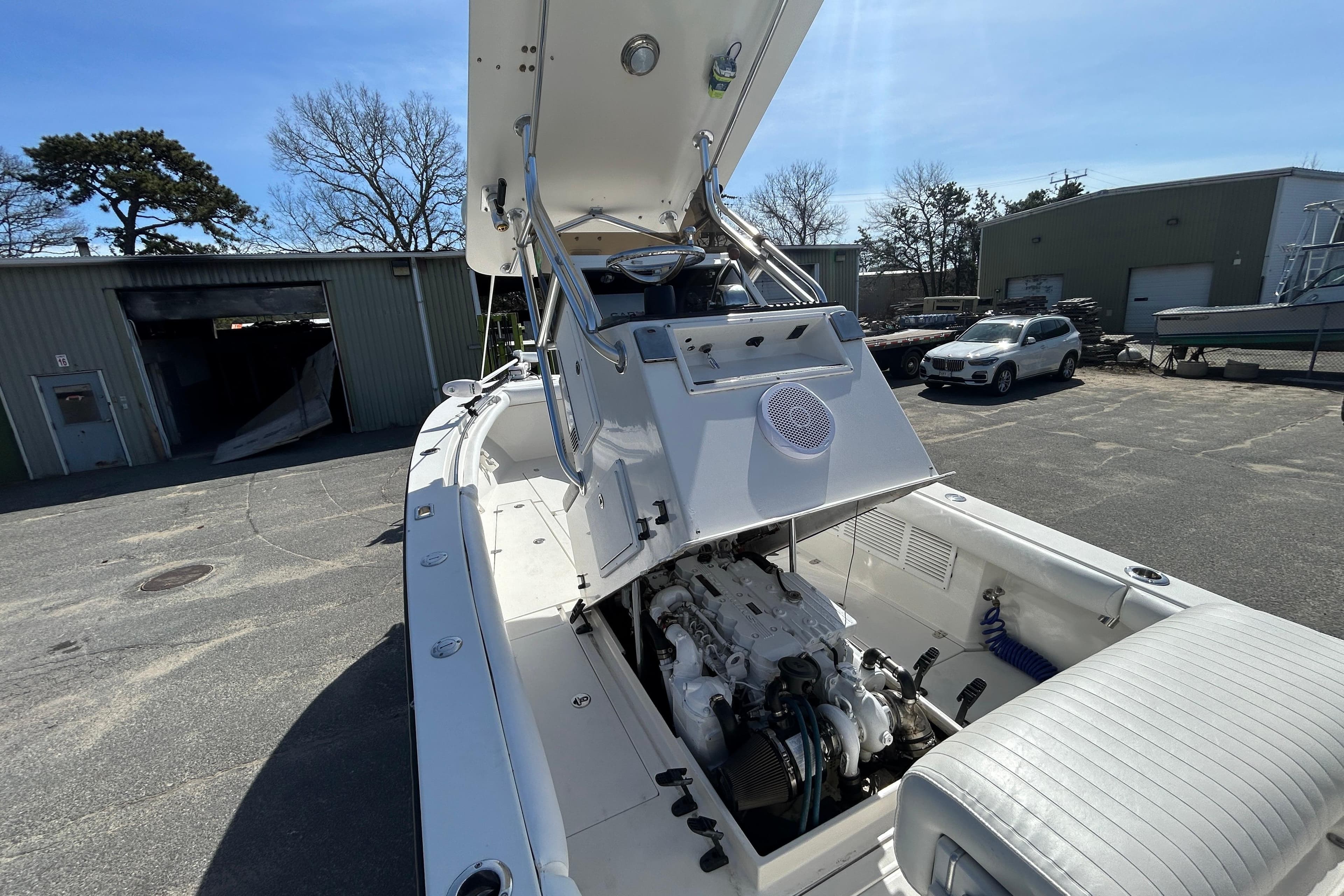 2006 Albin 26 Center Console boat with open engine compartment in a marina setting.