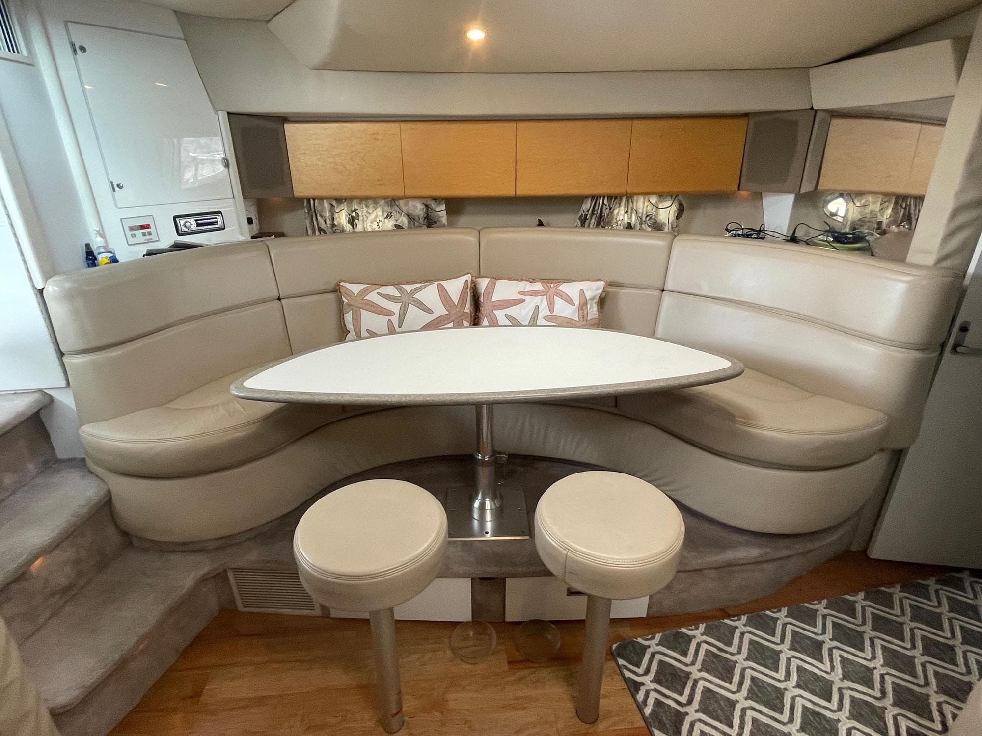 1998 Formula 41 PC yacht interior with curved seating, table, and stools.