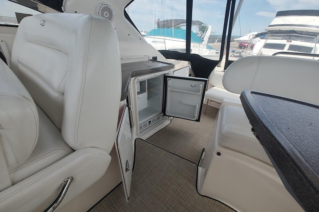 Interior of 2006 Regal Commodore 3560 IO yacht with open mini fridge and seating area.