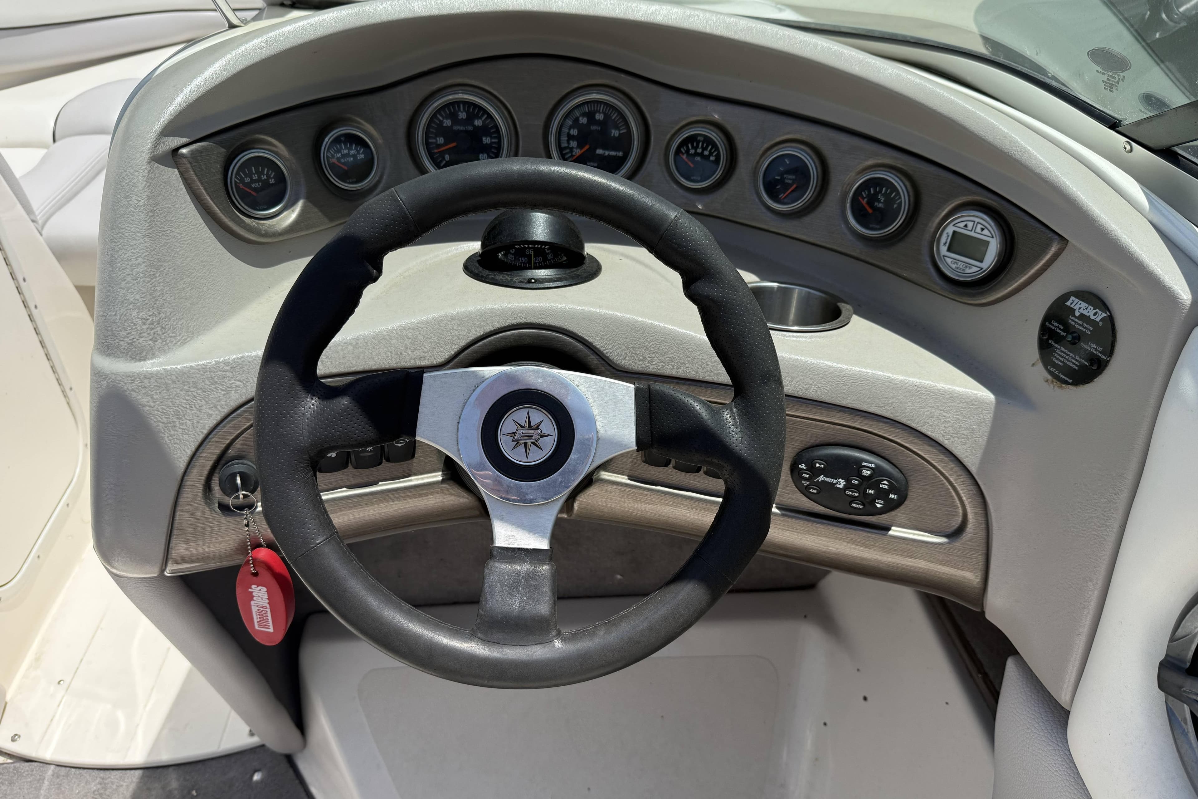 Steering wheel and dashboard of a 2010 Bryant 233 boat, featuring multiple gauges.