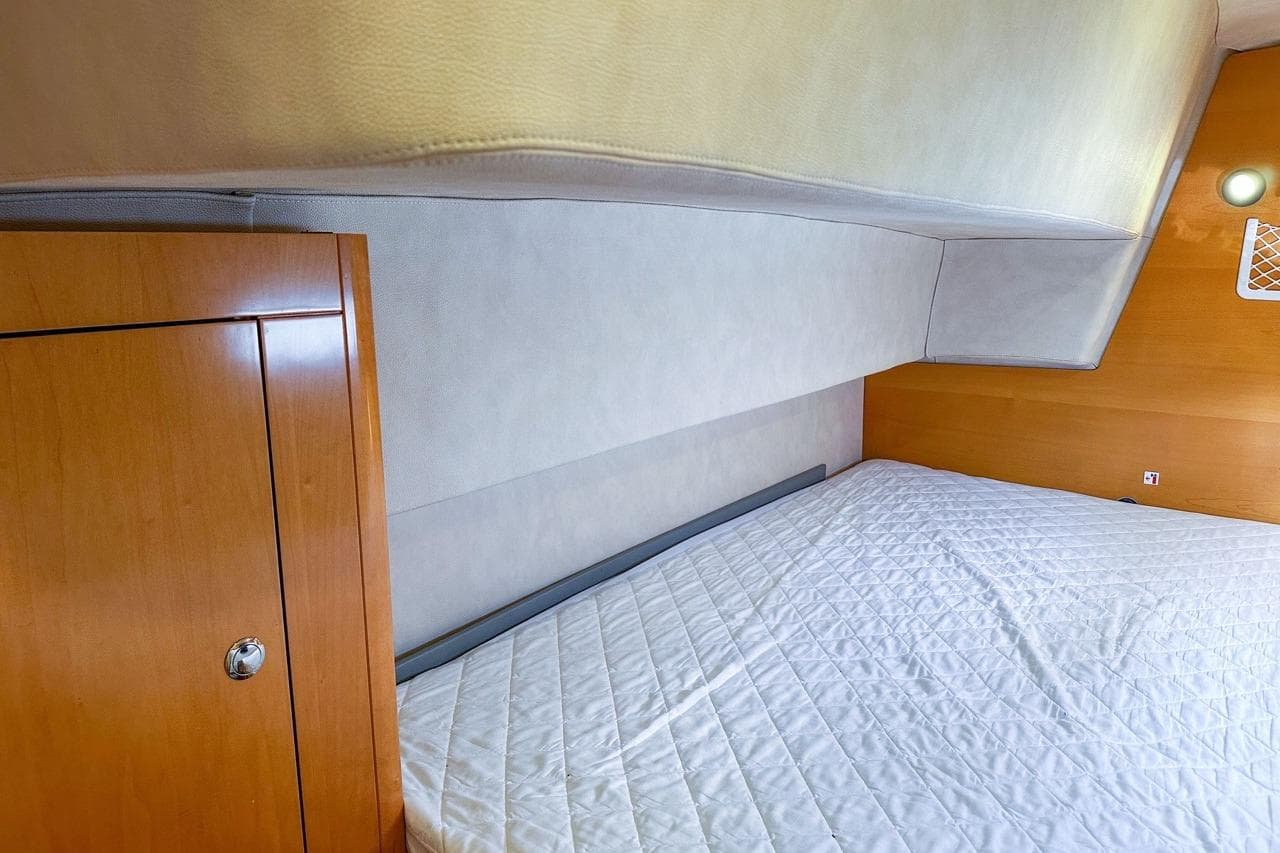 Cozy cabin interior of 2006 Fountaine Pajot Highland 35 Pilot with wooden accents and quilted bedding.